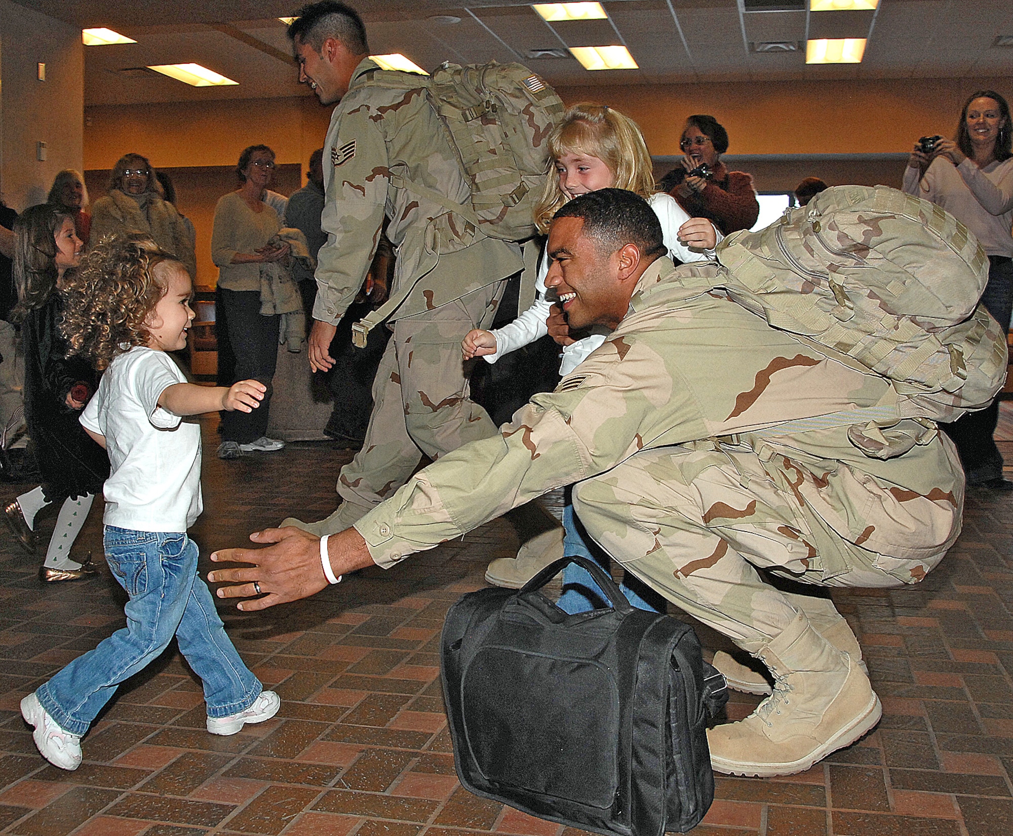 Senior Airman Jesse Mitchell is seconds away from holding his 2-year-old daughter Jayda in a happy reunion at the Sunport. U.S. Air Force photo by Todd Berenger
