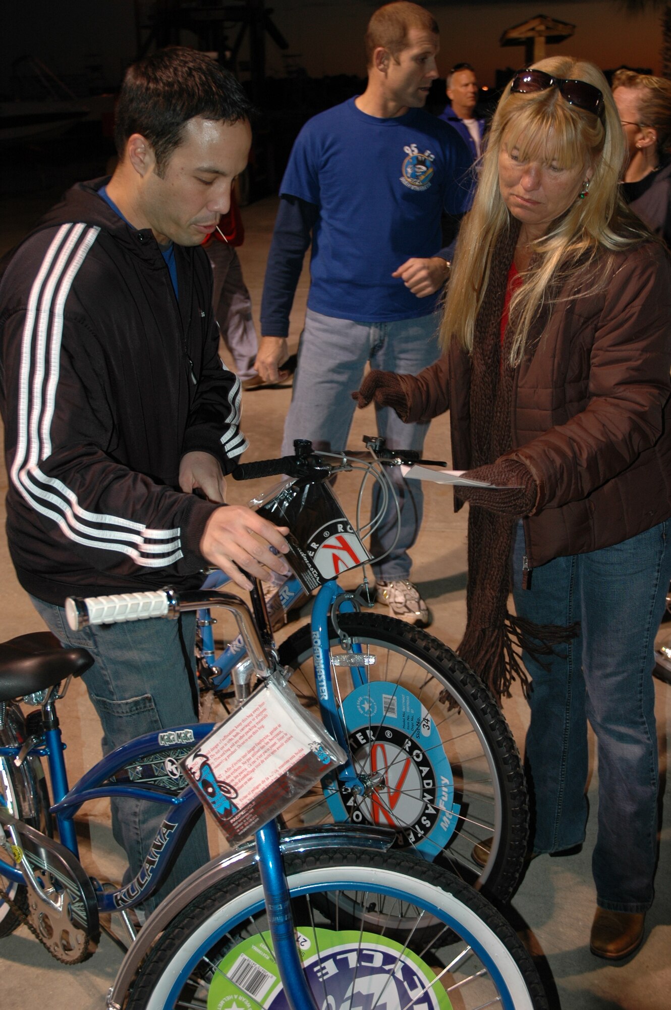 Maj. Andre Maugeri, 325th Operations Group instructor pilot, plays the role of the runner Monday night during the Ardry's Bikes for Tykes program.  Major Maugeri, one of 30 plus volunteers from Tyndall Air Force Base, retrieved bikes according to a card and handed them to the parents to whom it belonged. (U.S. Air Force photo by Airman 1st Class Anthony J. Hyatt)