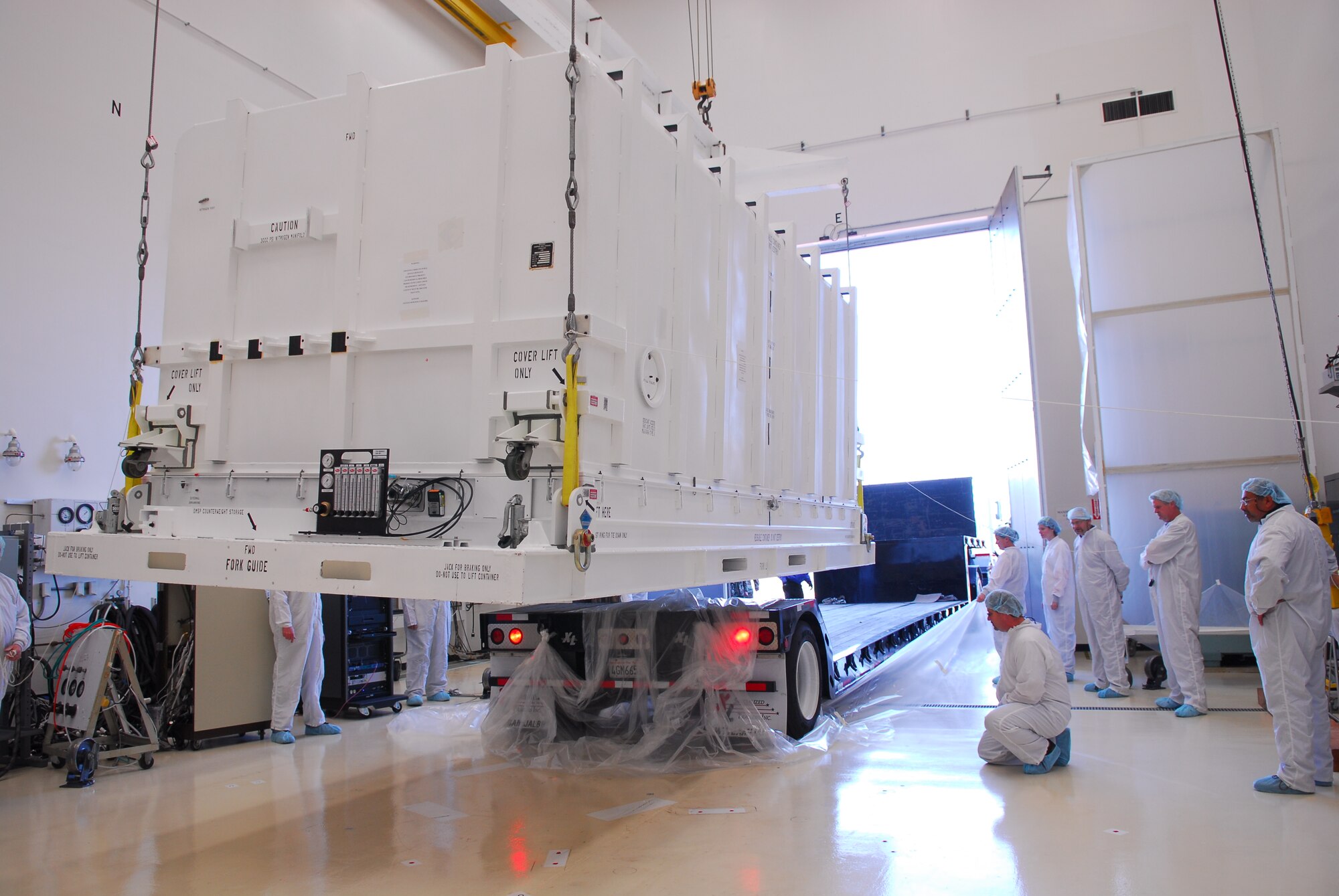 VANDENBERG AIR FORCE BASE, Calif. -- Lockheed Martin personnel watch carefully as a flatbed truck drives off while the Defense Meteorological Satellites Program satellite is lifted before being uncovered, here on Dec. 14. The DMSP satellite monitors solar-terrestrial physics and provides photographic reconnaissance and surveillance for the U.S. Department of Defense. It's a valuable tool in scheduling and protecting military operations in the Air Force.
(U.S. Air Force photo/Airman 1st Class Ashley Tyler)