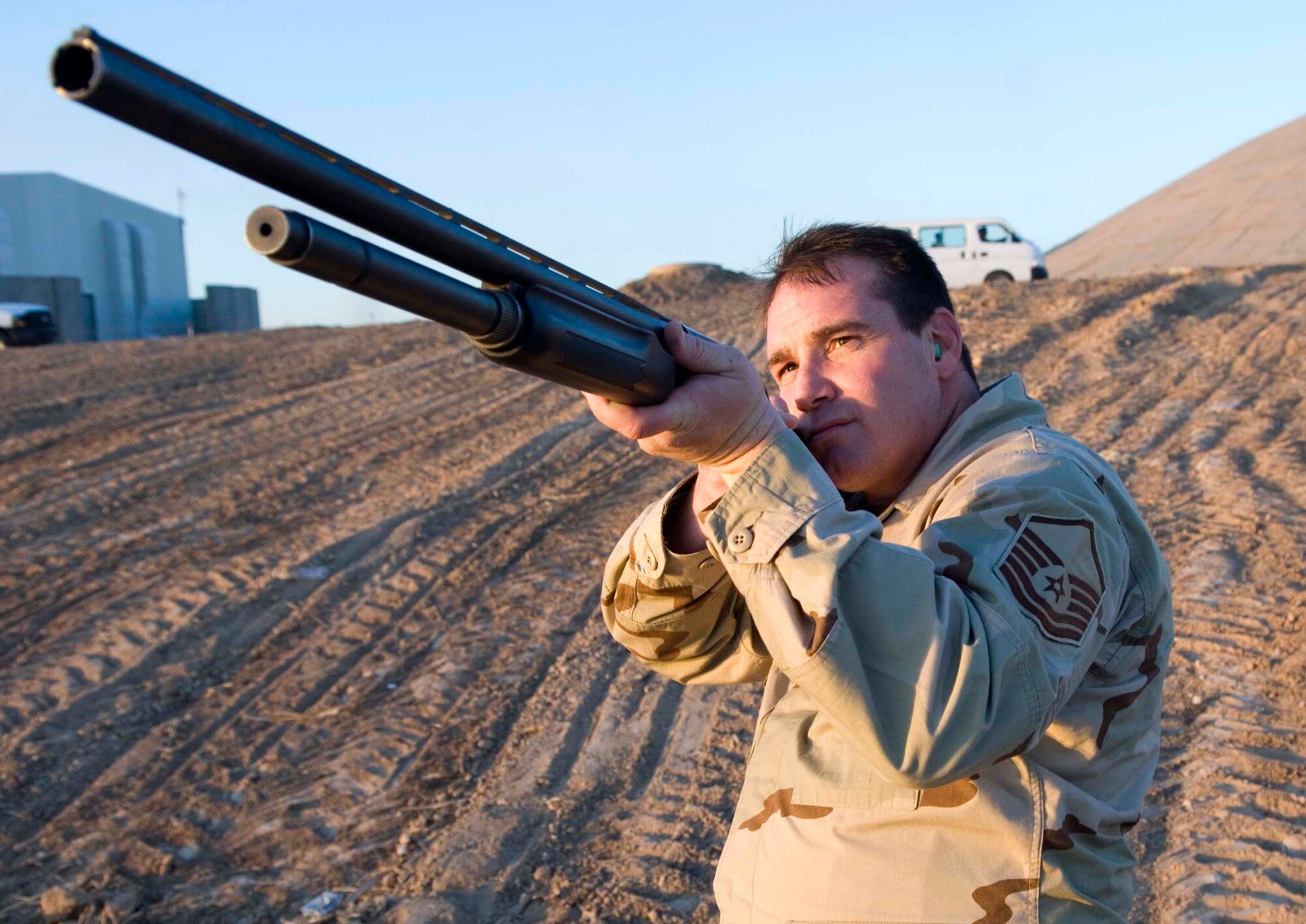 Master Sgt. Brian Saunders lines up his next shot with a 12-gauge shotgun equipped with "bird scare" Dec. 14 at Balad Air Base, Iraq. The bird scare is shot in the general vicinity of nesting birds and makes a loud noise comparable to a bottle rocket to scare the birds away from the flightline area. Sergeant Saunders and base volunteers helped reduce the number of bird strikes by 30 percent in November. Sergeant Saunders is with the 332nd Air Expeditionary Wing Safety Office and is deployed from Aviano Air Base, Italy. (U.S. Air Force photo/Staff Sgt. Travis Edwards) 