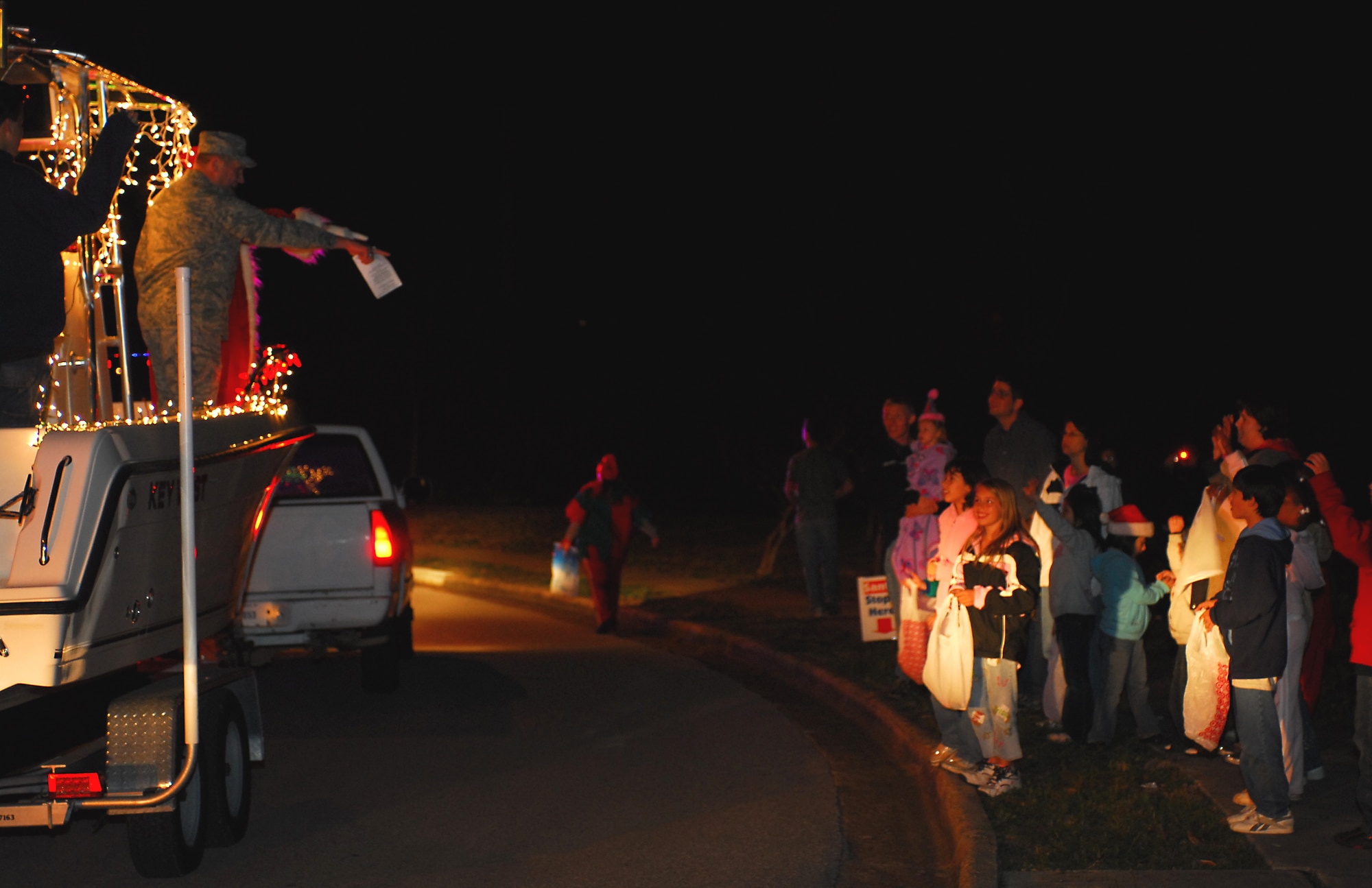 Col. Mike Smietana, 1st Special Operations Mission Support Group commander, rode alongside Santa in a patrol boat instead of a sleigh Dec. 18 during the Jingle Jangle Sing-A-Long parade at Hurlburt Field. Volunteers sang carols and elves passed out candy to children watching the parade. (U.S. Air Force photo/Airman 1st Class Jason Epley)