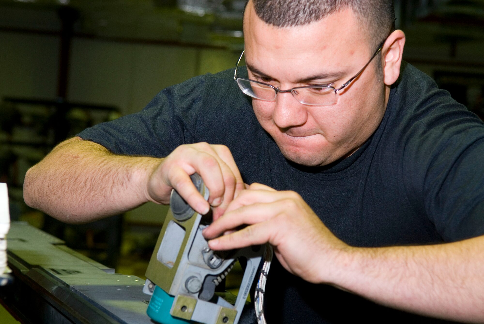 BALAD AIR BASE, Iraq -- Staff Sgt. Raul Maldonado, a 332nd Expeditionary Maintenance Squadron armament maintainer, disconnects 129-Missile Launcher wire harness from a 120 umbilical wire assembly here, Dec. 19. The wire harness controls the electrical components on the missile launcher. Sergeant Maldonado is deployed from Hill Air Force Base, Utah. (U.S. Air Force photo/Staff Sgt. Joshua Garcia)