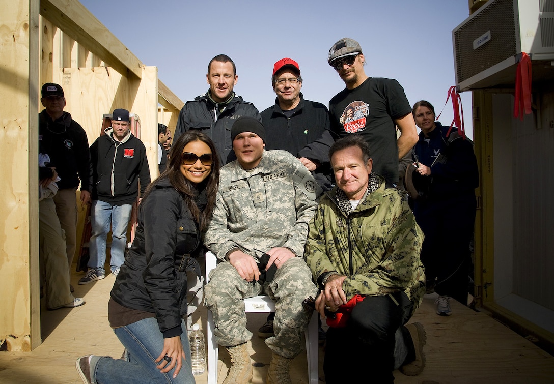 Seven time Tour de France champion Lance Armstrong, comedian Lewis Black, musician Kid Rock, Miss USA Rachel Smith and comedian Robin Williams pose for a photo with wounded warrior U.S. Army Cpl. Jordan West of Chicago during the 2007 USO Holiday Tour stop at Logistics Support Area Anaconda, Balad, Iraq, Dec. 20, 2007. 