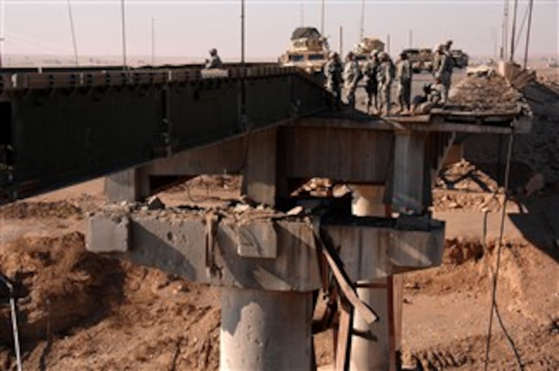 U.S. Army soldiers from 1st Squadron, 3rd Armored Cavalry Regiment, survey a bridge destroyed by a vehicle-borne improvised explosive device in Q-West, Iraq, Dec. 9, 2007. The bridge is temporarily restored, allowing passage until reconstruction begins.