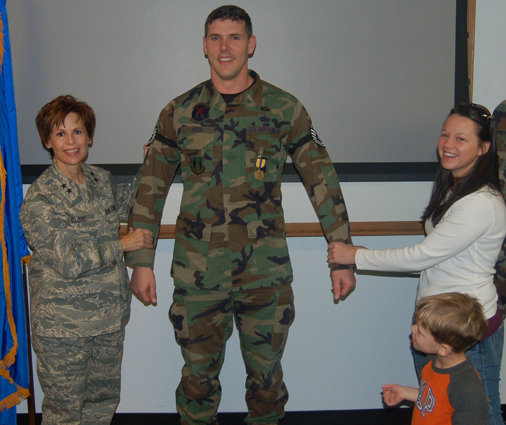 Tech. Sgt. Cory Hebb, 75th Security Forces Squadron, stands with Maj. Gen. Kathleen Close, Ogden Air Logistics Center commander, his wife, Tiffany, and 4-year-old son, Canyon, after he was promoted Dec. 21. General Close promoted Sergeant Hebb under the Stripes for Exceptional Performers program.