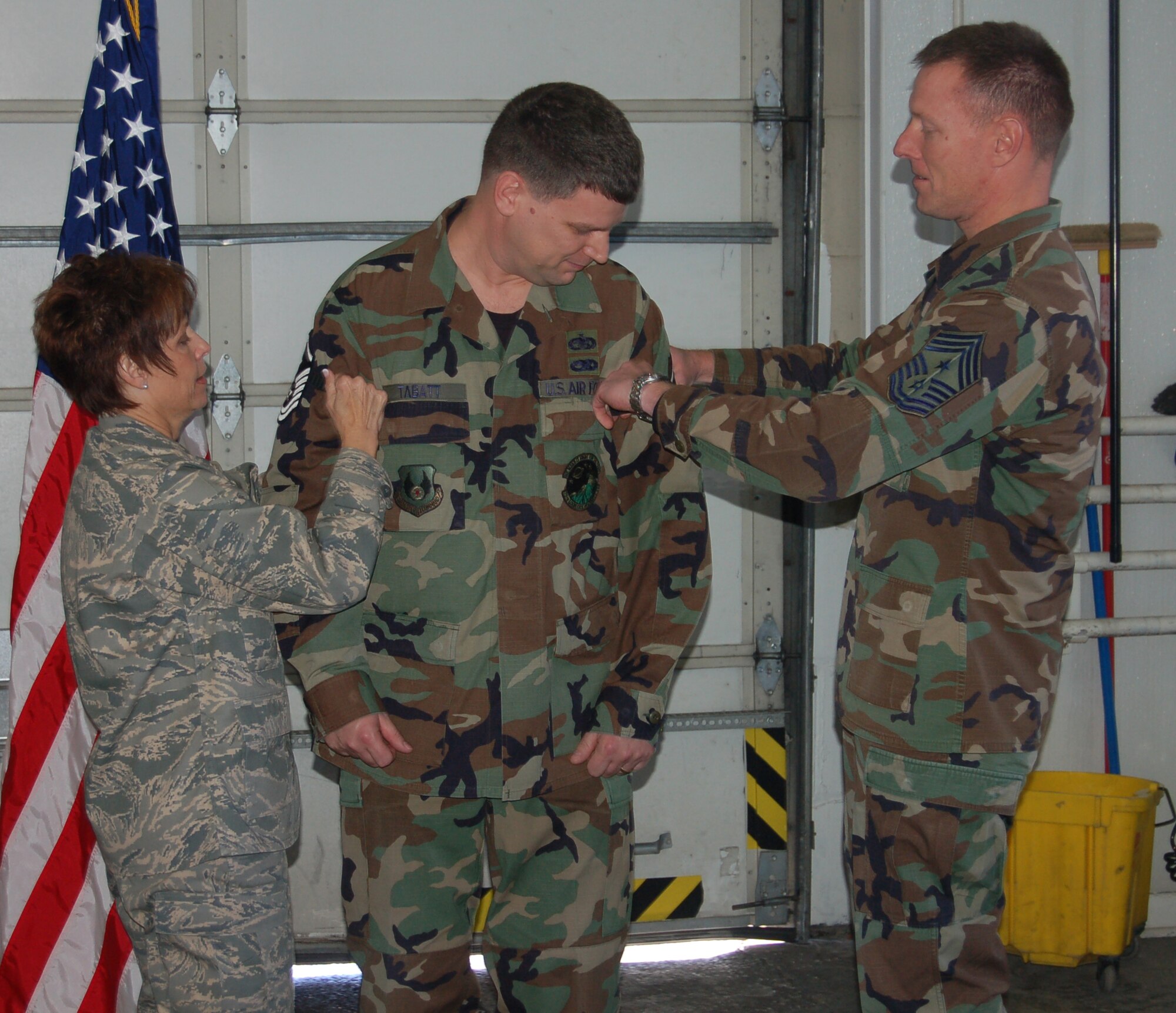 Maj. Gen. Kathleen Close, Ogden Air Logistics Center commander, and Chief Master Sgt. William Gurney (right), 75th Air Base Wing and OO-ALC command chief, prepare to "tack” master sergeant stripes onto Mark Tabatt, 75th Logistics Readiness Squadron, Dec. 21. Sergeant Tabatt was promoted by General Close under the Stripes for Exceptional Performers program. (U.S. Air Force Photo by Senior Airman Brok McCarthy)