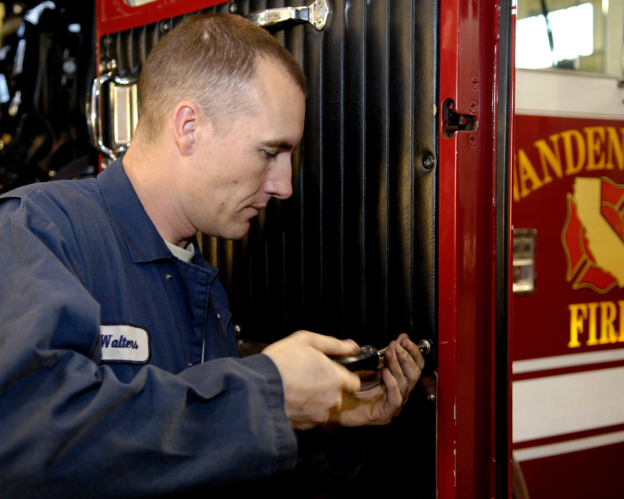 VANDENBERG AIR FORCE BASE, Calif. -- Staff Sgt. Jason Walters, 30th Logistics Readiness Squadron, screws a door panel to a fire engine on Dec. 5.  Staff Sgt. Walters recently returned from convoy duty in Iraq while stationed at Camp Arifjan, Kuwait. (U.S. Air Force photo/Airman 1st Class Jonathan Olds)
