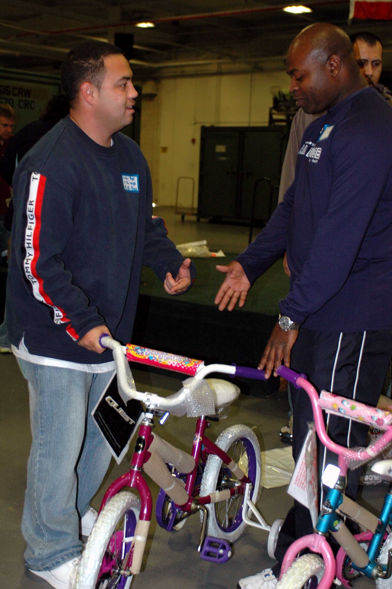 Staff Sgt. Mike Palmer, 860th Aircraft Maintenance Squadron, receives a bike from Master Sgt. Clifton Shockley, 660th AMXS first sergeant and event coordinator, at the Toys for Troops event in Hangar P-1 Dec. 20. The event, hosted by the Airman and Family Readiness Center, gave Team Travis a chance to look through and choose Christmas toys for their children. (U.S Air Force photo/Staff Sgt. Matthew McGovern)