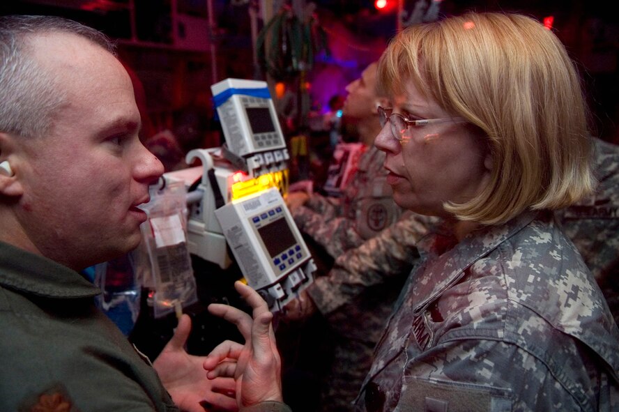 Maj. (Dr.) Julio Lairet discusses in-flight procedures for transporting burn victims with Maj. Elizabeth Mann, a registered nurse with the special medical augmentation response team at Brooke Army Medical Center, during the C-130 Hercules simulator training portion of critical care air transport team training. (U.S. Air Force photo/Steve Thurow) 