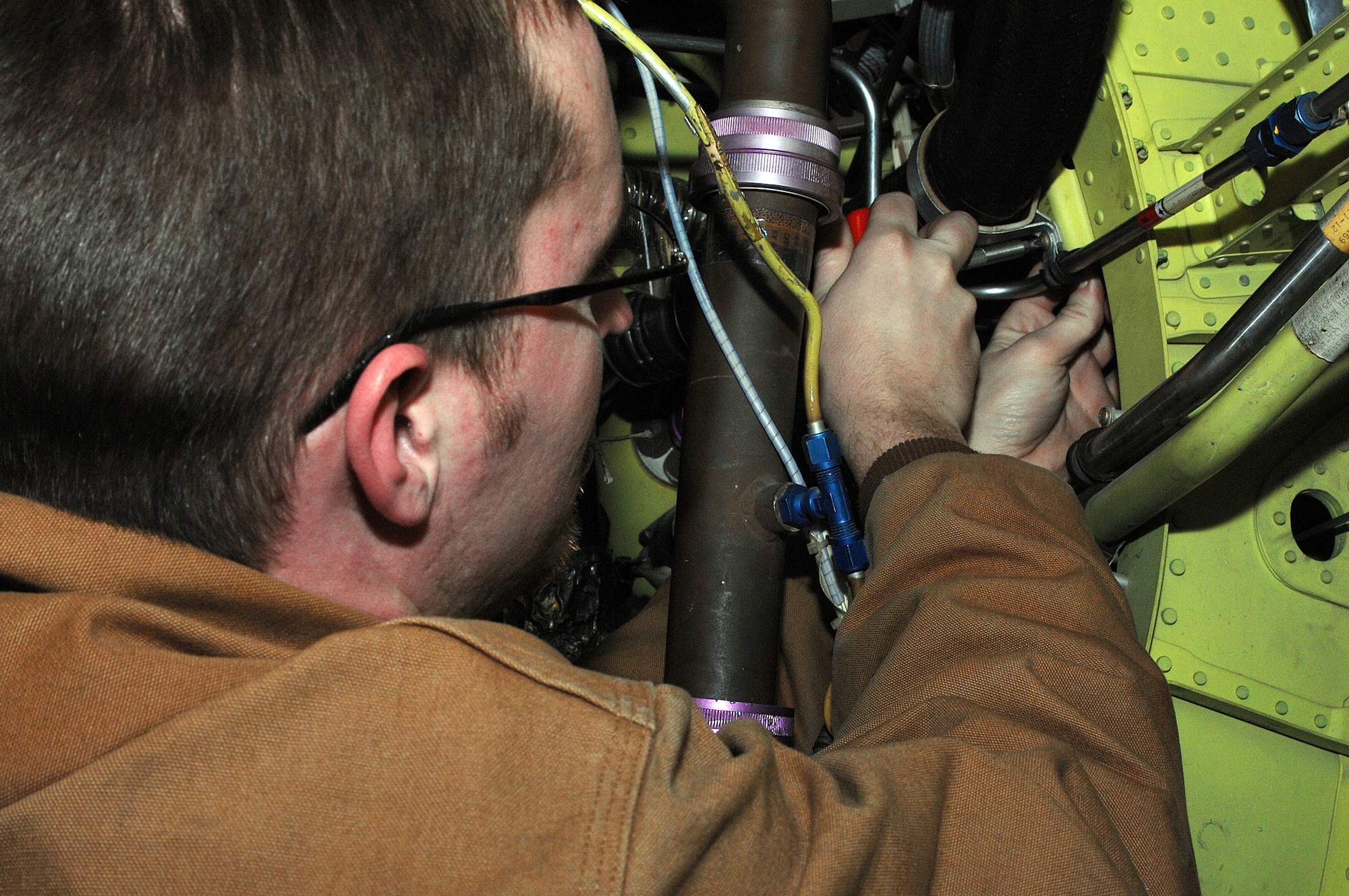 Senior Airman Brian Ryberg, 442nd Aircraft Maintenance Squadron, installs clamps on a lower engine hose in an A-10 Thunderbolt II Dec. 19 at Whiteman Air Force Base, Mo.  Airman Ryberg is an Air Reserve Technician in the 442nd Fighter Wing, an Air Force Reserve unit that operates, maintains and supports a squadron of A-10 ground-attack aircraft. (U.S. Air Force photo/Tech. Sgt. Samuel A. Park)