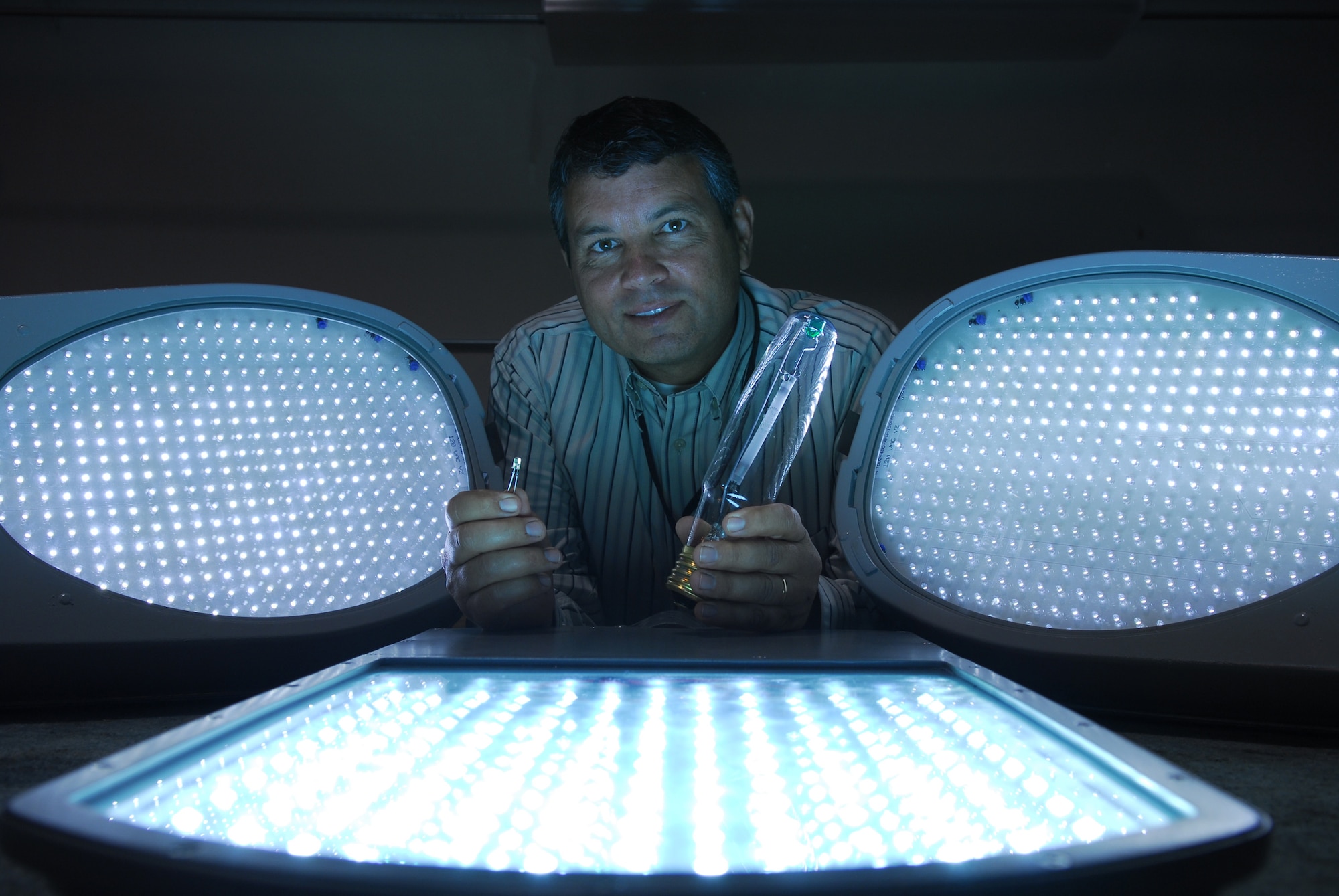 VANDENBERG AIR FORCE BASE, Calif. -- Scott Bly, 30 Civil Engineering Squadron, poses with regular light bulbs and Light Emitting Diode lights during the testing of several lights on Oct. 23. The test was conducted to determine which street light works better to save millions of dollars in energy cost base wide.  (U.S. Air Force photo/Airman 1st Class Ashley Tyler)