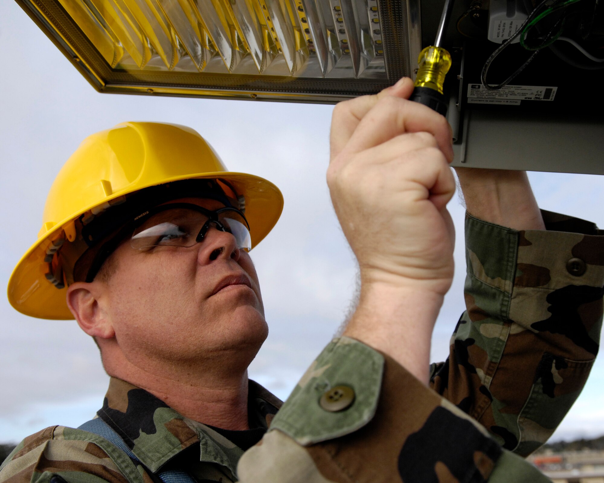 VANDENBERG AIR FORCE BASE, Calif. -- Master Sgt. Russell Wells, 30th Civil Engineering Squadron, inspects a Light Emitting Diode in front of the CES Operations Flight Building on Dec. 17. LED lights are being tested on Vandenberg to possibly replace current sodium vapor lamps. LED lights use three times less energy than sodium vapor lamps. (U.S. Air Force photo/Airman 1st Class Jonathan Olds)