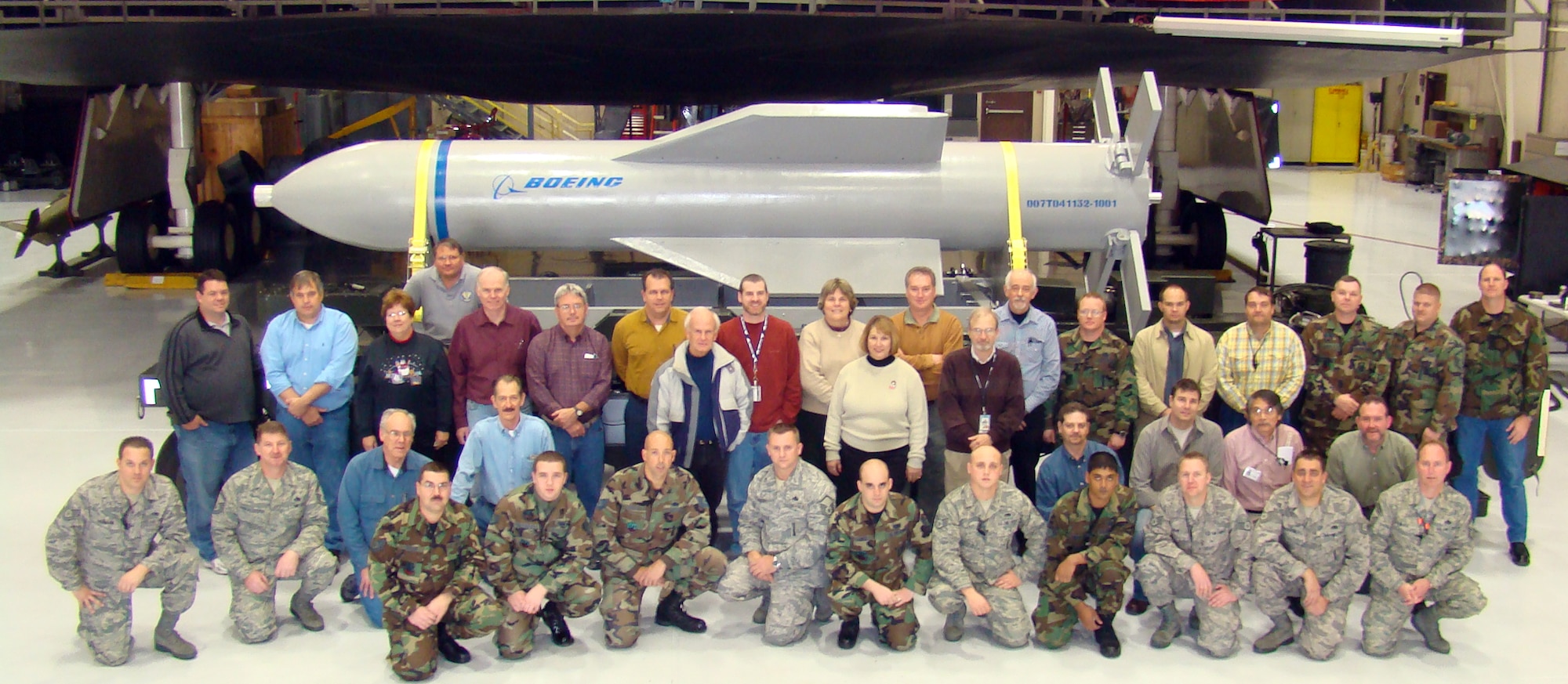 WHITEMAN AIR FORCE BASE, Mo. - Weapon specialists pose for a photo in front of a mock up of the Massive Ordnance Penetrator and the B-2 weapons load trainer Dec. 18. (Photo printed with permission of Col. Bob Dulong)