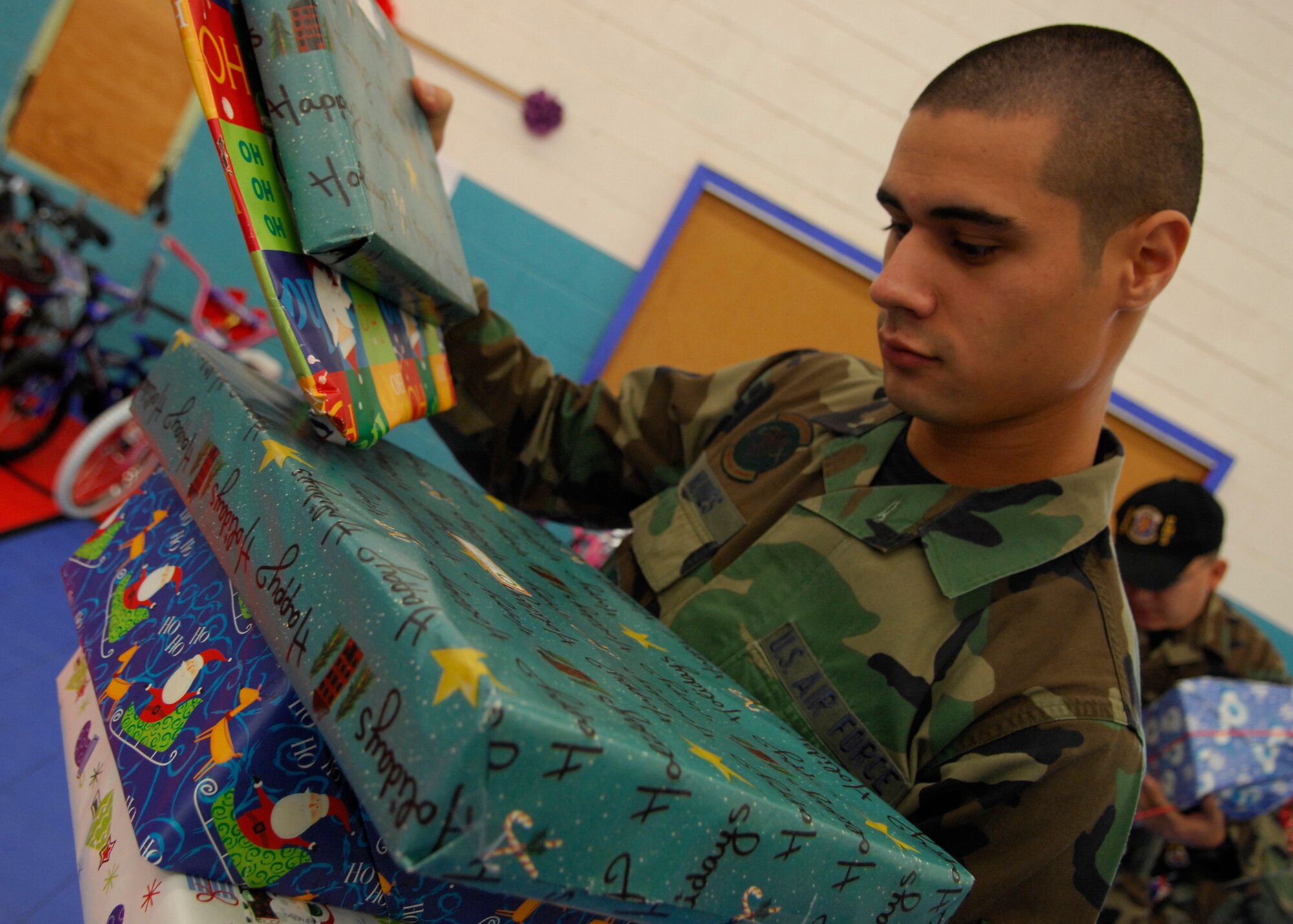 A1C Alexander Nunes from 355th Equipment Maintenance Squadron sorts through gifts donated from the 355th Wing during "Santa's in Blue" Thursday December 20th this is an ongoing event that has been occurring within the community many years. It involves Airmen from Davis-Monthan handing out Christmas presents to more than 400+ children grades K-3 of the Tohono O'odham Indian Reservation. For many of these children it will be the only gifts they receive for the holiday season. This year features a special guest appearance from Santa who flew in on an HH-60. (U.S. Air Force Photo by Senior Airman Jesse Shipps)(Released)