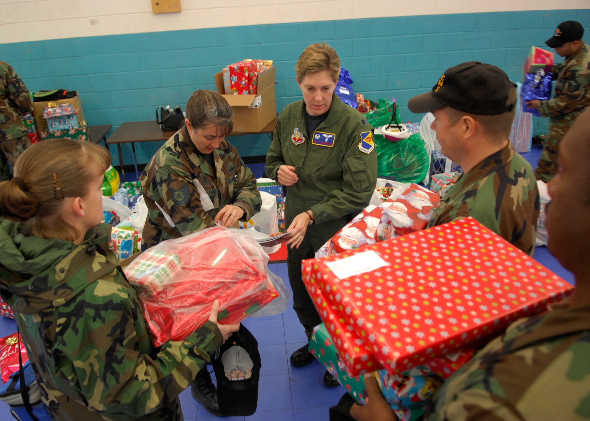 Members from 355th Fighter Wing sort through gifts donated from the 355th Fighter Wing during "Santa's in Blue" Thursday December 20th This is an ongoing event that has been occurring within the community many years. It involves Airmen from Davis-Monthan handing out Christmas presents to more than 400+ children grades K-3 of the Tohono O'odham Indian Reservation. For many of these children it will be the only gifts they receive for the holiday season. This year features a special guest appearance from Santa who flew in on an HH-60. (U.S. Air Force Photo by Senior Airman Jesse Shipps)(Released)