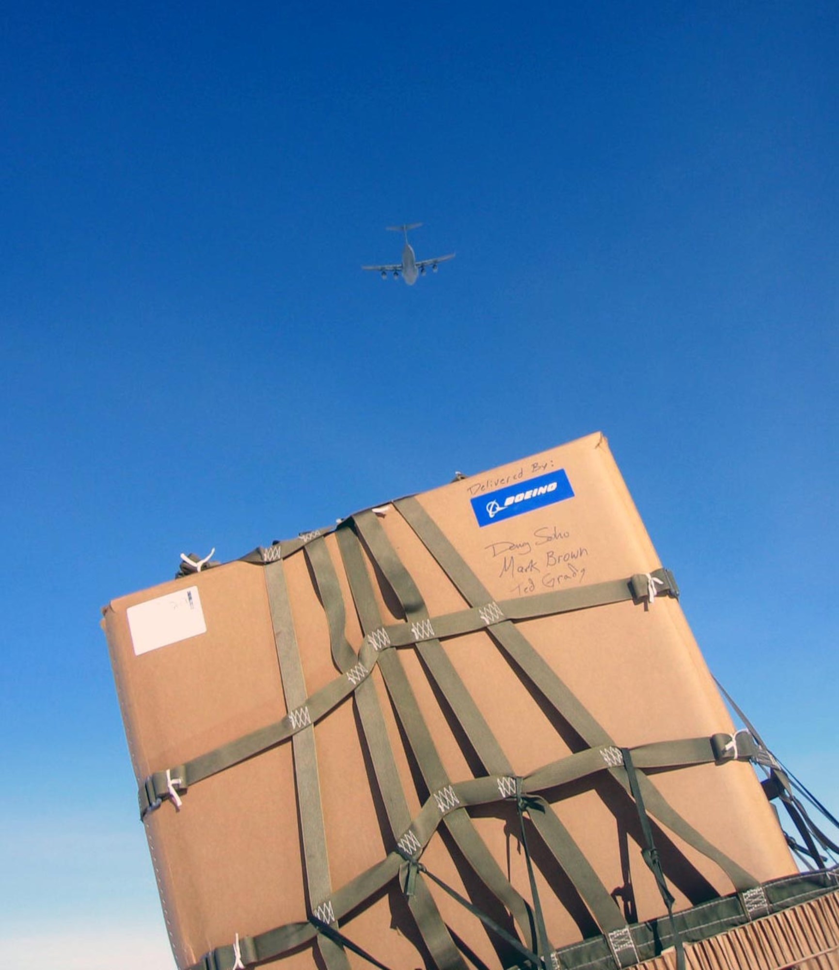A C-17 Globemaster III flys above a containerized delivery system bundle just airdropped to the South Pole Dec. 18. By validating the C-17 capability to complete airdrop missions at the Geographical South Pole, Joint Task Force-Support Forces Antarctica demonstrated its ability to provide mid-winter emergency re-supply and flexible support to the National Science Foundation and U.S. Antarctica Program. (U.S. Air Force photo) 