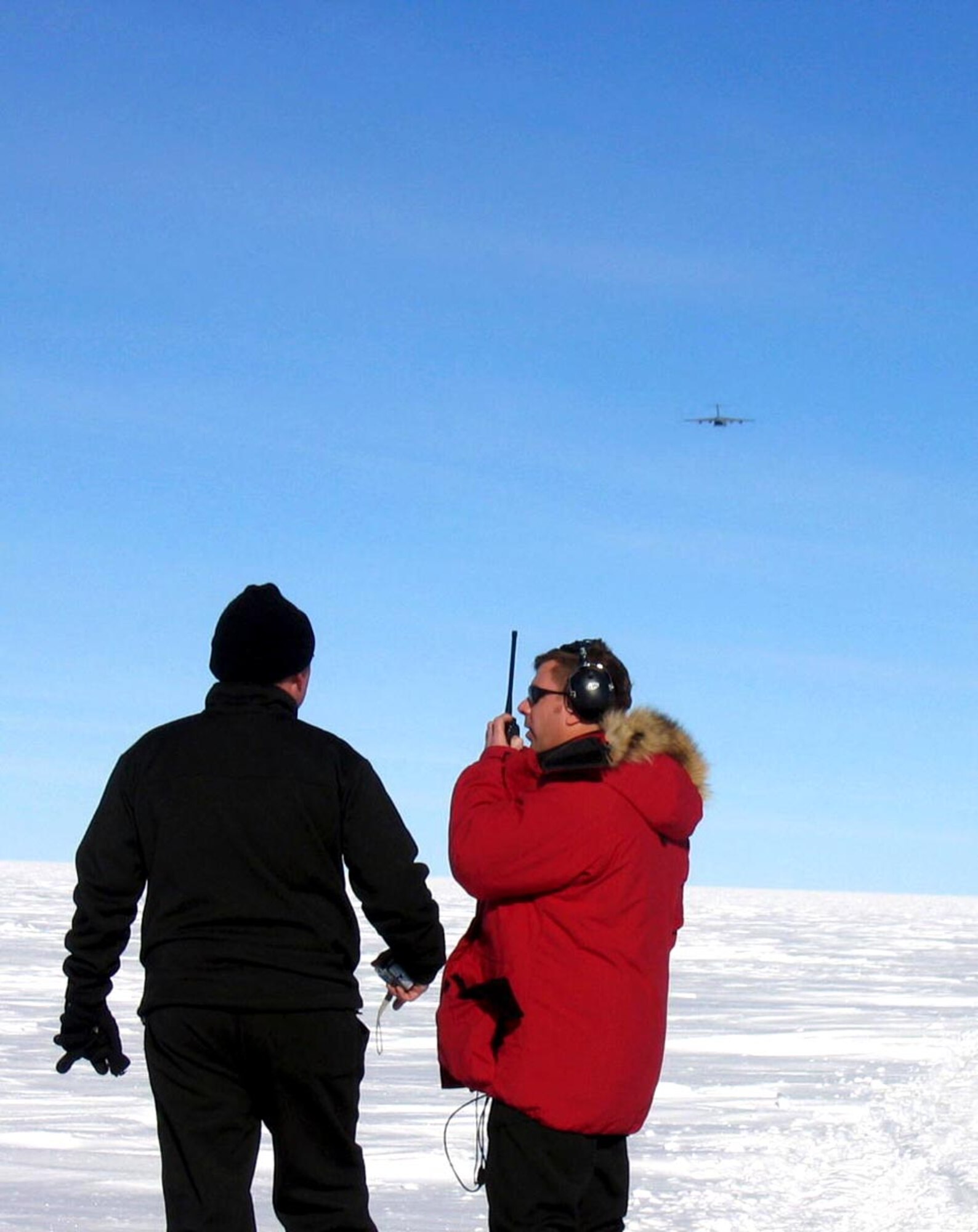 A drop zone controller guides the C-17 Globemaster III aircrew members during the containerized delivery system airdrop of supplies Dec. 18 to the South Pole. By validating the C-17 capability to complete airdrop missions at the Geographical South Pole, Joint Task Force-Support Forces Antarctica demonstrated its ability to provide mid-winter emergency re-supply and flexible support to the National Science Foundation and U.S. Antarctica Program. (U.S. Air Force photo) 