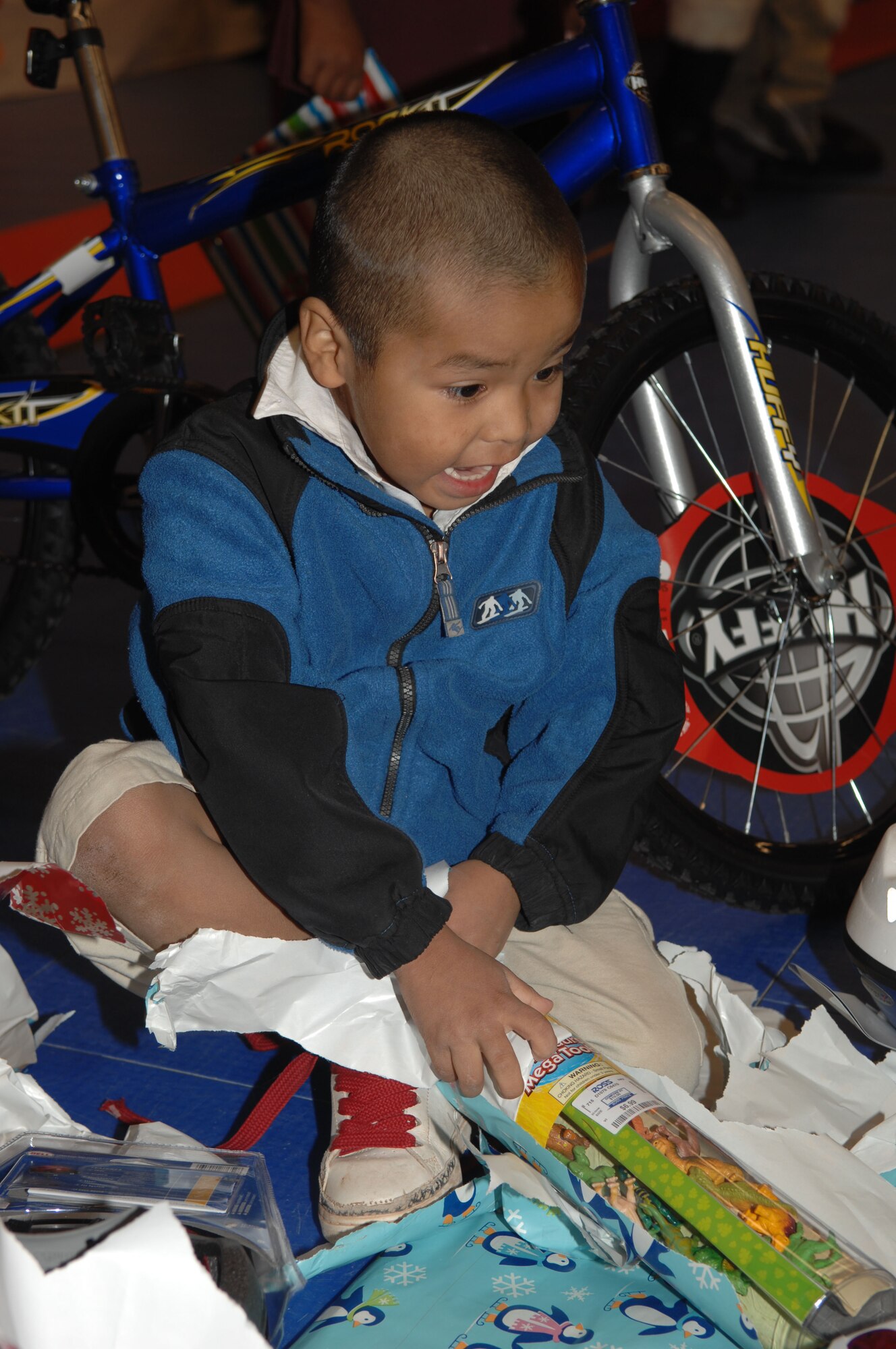 A student at Indian Oasis Elementary School displays his excitement while opening Christmas presents provided by various units at D-M for the Santa's In Blue program. Numerous volunteers from the Desert Lightning community assisted Santa in distributing the presents.  (U.S. Air Force photo by Airman 1st Class Melissa Copeland) 