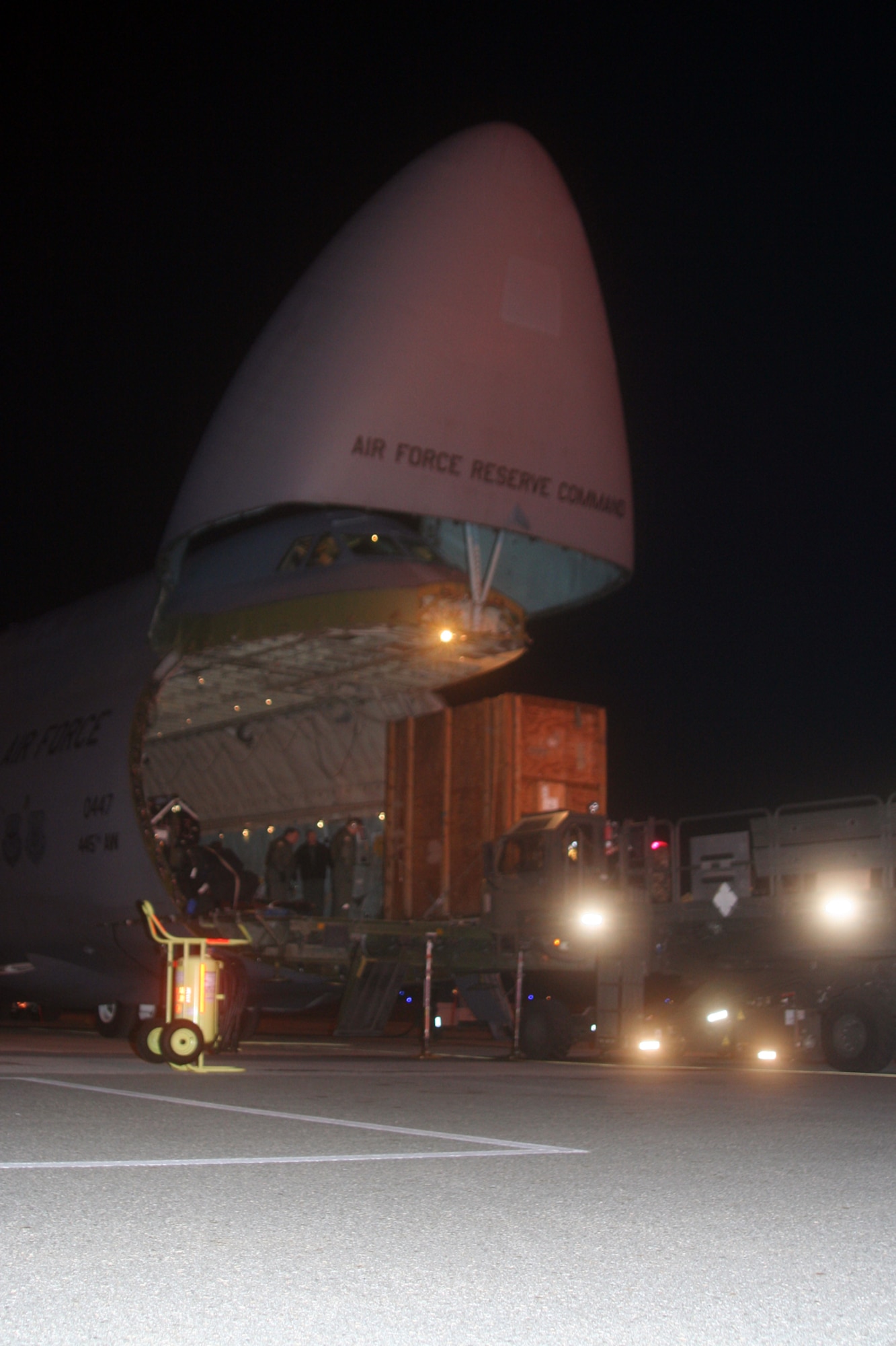 DOVER AIR FORCE BASE, Del --   A 60K-Tunner Material Loader, commonly called a K-loader, pulls forward to load equipment and supplies on a C-5 aircraft with loadmasters monitoring the loading. (U.S. Air Force photo/Maj. Ted Theopolos)