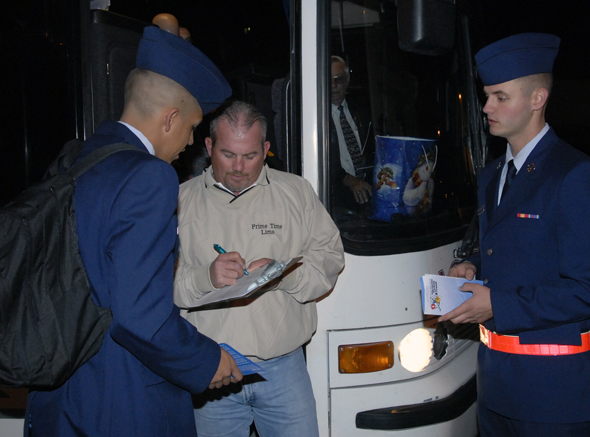 An employee of Prime Time Limo checks a passenger manifest Dec. 21 as Sheppard Airmen inTraining get ready to board a bus to go home for the holidays. More than 2,500 AiTs departed Sheppard by bus, shuttle or limousine between midnight and 11:30 a.m. (U.S. Air Force photo/Sandy Wassenmiller)