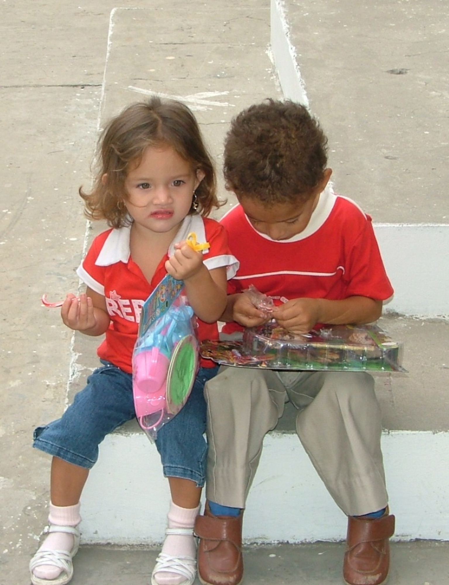 Two children at OSCUS, a vocational school in Manta, Ecuador, play with their toys that were given to them as part of the FOL Manta’s Toys for Tots program.  This year the members of the FOL were able to hand out more than 4500 toys to 20 different local organizations.  (U.S. Air Force photo/1st Lt. Malinda Singleton)