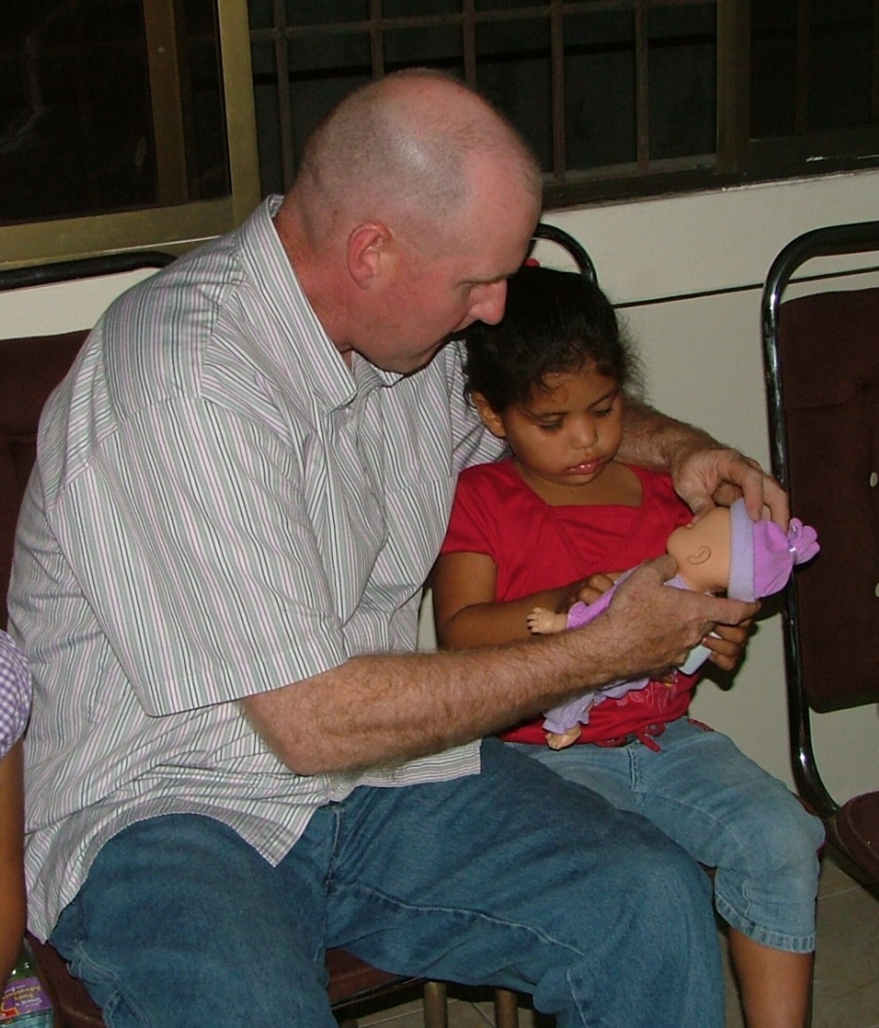 Senior Master Sgt. Clayton French, 478th Expeditionary Operations Squadron first sergeant, helps a girl at Shekinah Orphanage in Manta, Ecuador with her new toy.  The toys were given out as part of the FOL Manta’s Toys for Tots program.  (U.S. Air Force photo/1st Lt. Malinda Singleton)