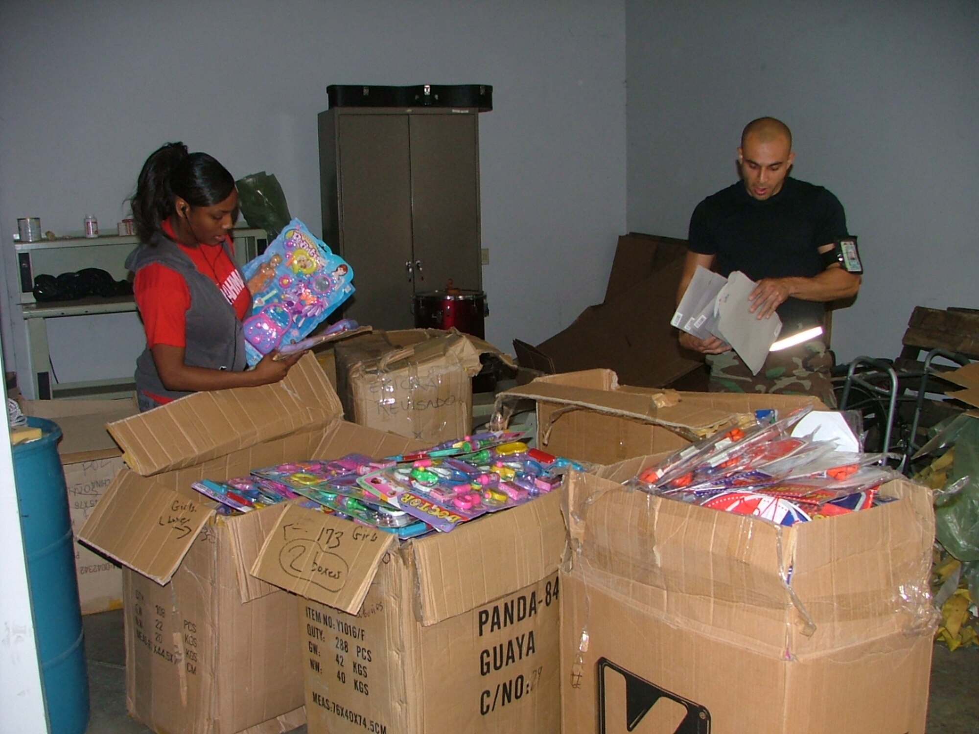 Airman 1st Class Mitia Jackson, who is deployed to FOL Manta from Langley AFB, and Senior Airman Omar Torres, who is deployed to the FOL from Tinker AFB, help sort more than 4500 toys.  The toys were handed out as part of the FOL Manta’s Toys for Tots program.  (U.S. Air Force photo/1st Lt. Malinda Singleton)