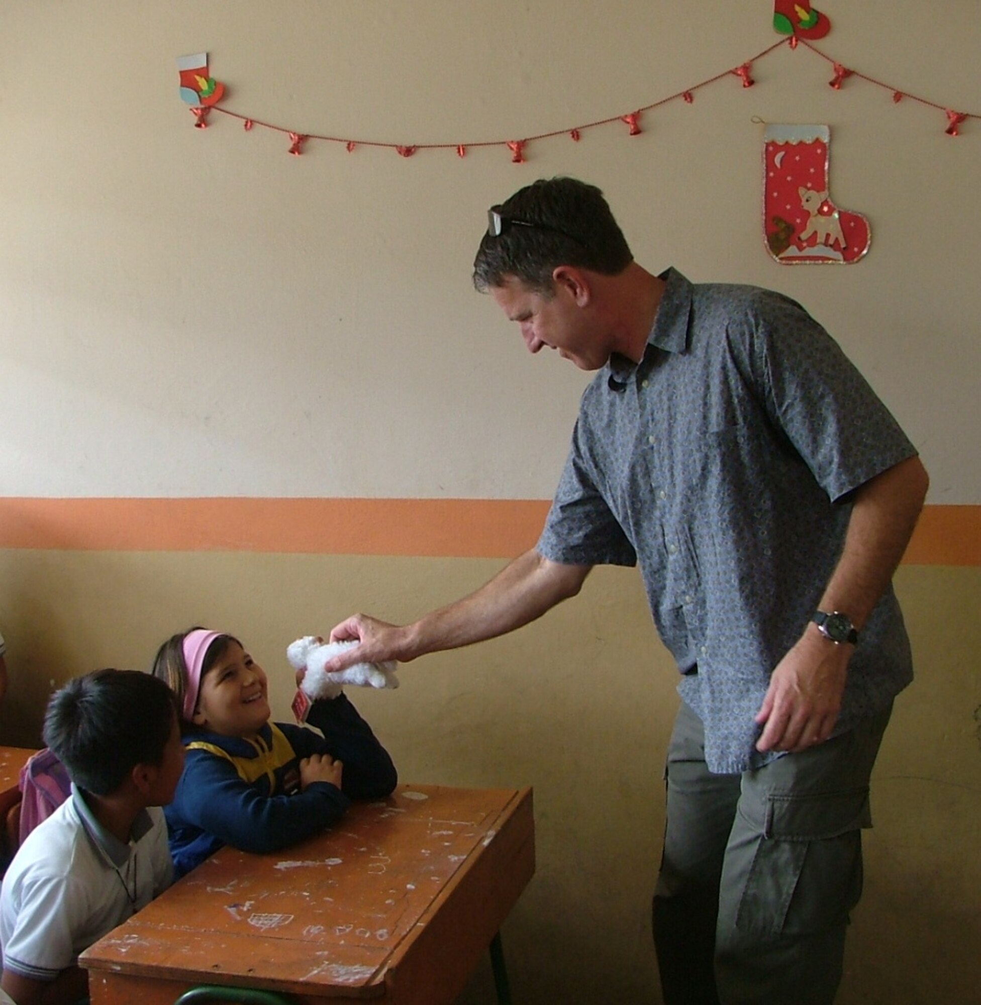 Lt. Col. Kirby Simmons, 478th Expeditionary Operations Squadron director of operations, passes out toys to children at a local school here in Manta, Ecuador.  The toys were given as part of the FOL Manta Toys for Tots program.  This year members of the FOL were able to hand out more than 4500 toys to 20 different local organizations. (U.S. Air Force photo/1st Lt. Malinda Singleton)