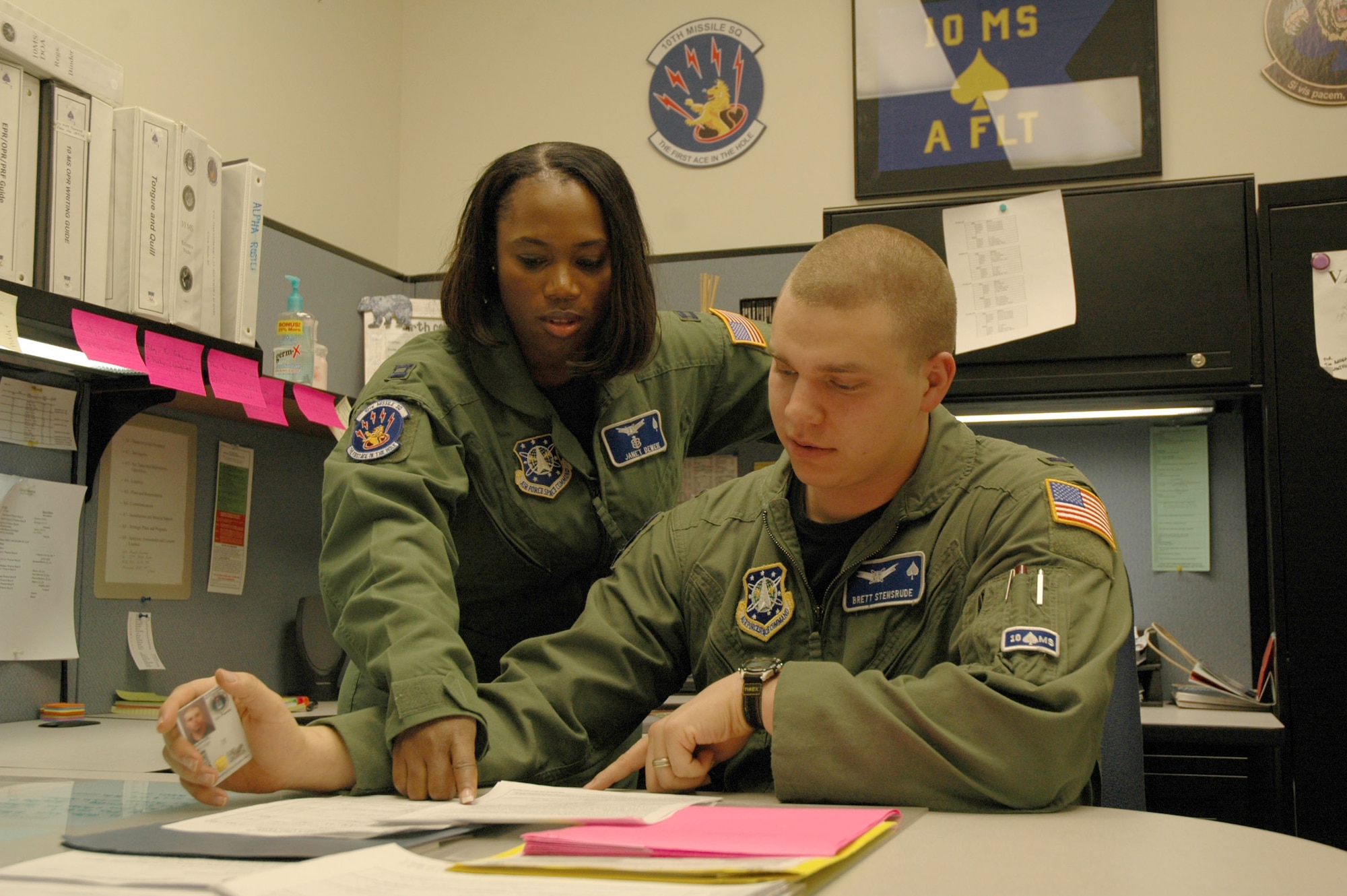 Capt. Janet Dewese, 10th Missile Squadron ICBM combat crew flight commander, mentors 1st Lt. Brett Stensrude, 10th MS ICBM combat crew member, on writing enlisted performance feedback reports. Captain Dewese will be deploying out to the missile field and serving through the holiday season. (U.S. Air Force photo/Airman 1st Class Emerald Ralston).
