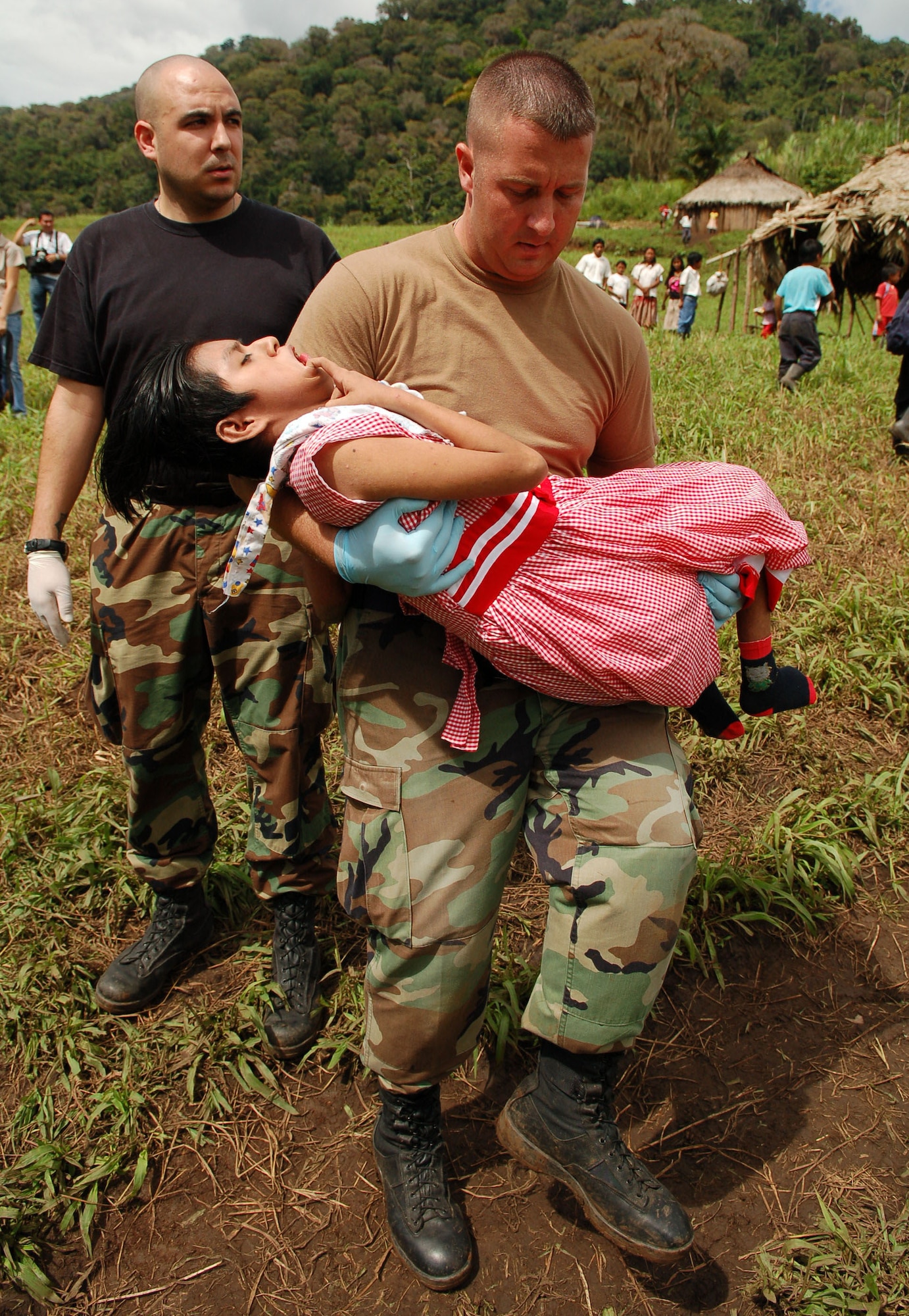 PIEDRA MESA, Costa Rica – Air Force Staff Sgts. Steven Geist (left) and David Pagani, Joint Task Force-Bravo Medical Element, take a young Costa Rican girl with cerebral palsy who has been diagnosed with pneumonia to a waiting helicopter to be air evacuated from a makeshift clinic to a hospital in Limon Dec. 18.  JTF-Bravo deployed 28 servicemembers from Soto Cano Air Base, Honduras to Costa Rica, at the invitation of the country’s Ministry of Health, for the first Medical Readiness Training Exercise in more than three years.  (U.S. Air Force photo by Staff Sgt. Austin M. May)