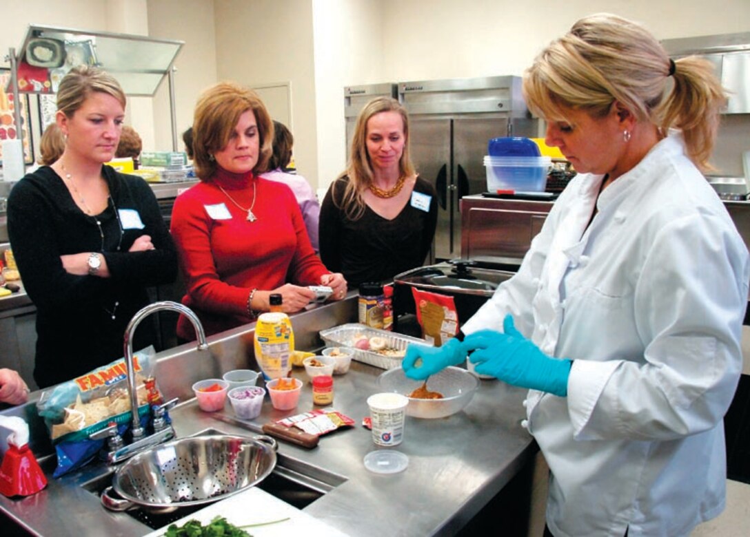 Tech. Sgt. Allison Miller prepares her favorite Mexican chicken salad during the Culinary Holiday hosted by the 89th Airlift Wing's flight attendants on Dec. 12. Sergeant Allison is a flight attendant assigned to the 99th Airlift Squadron. (US Air Force/Bobby Jones)
