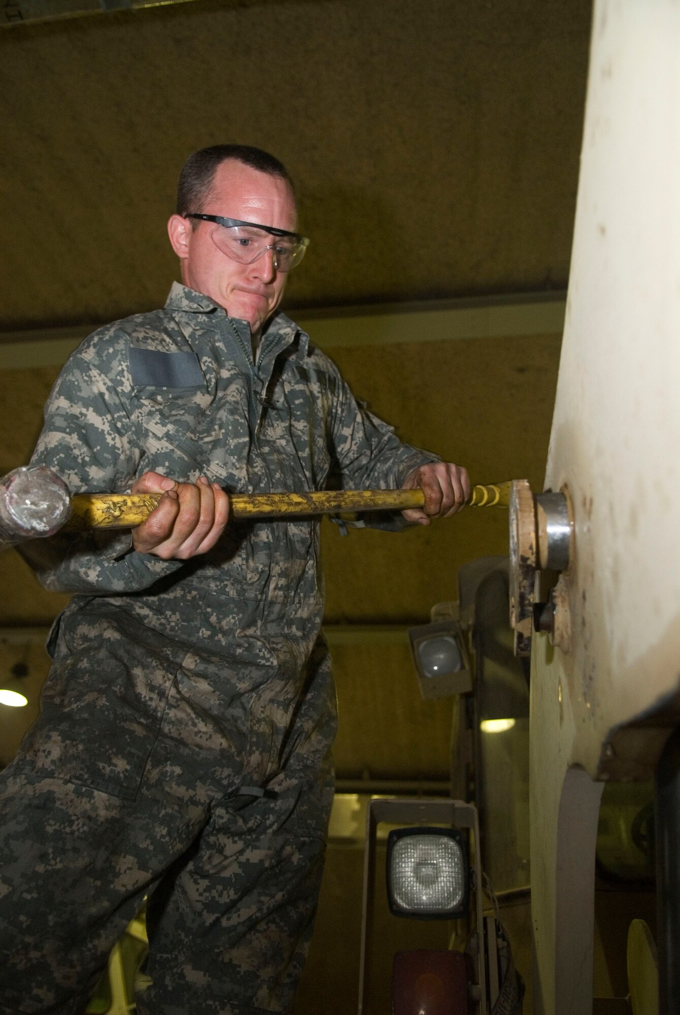 BALAD AIR BASE, Iraq -- Master Sgt. Brian Temple, the 332nd Expeditionary Logistics Readiness Squadron special purpose vehicle non-commissioned officer in charge, hammers a hydraulic cylinder hold down pin, for a 10K all terrain fork lift, into place here Dec. 21. The forklift is used for uploading and transporting cargo at the aero port. Sergeant Temple is deployed Little Rock Air Force Base, Ark. (U.S. Air Force photo/Staff Sgt. Joshua Garcia)