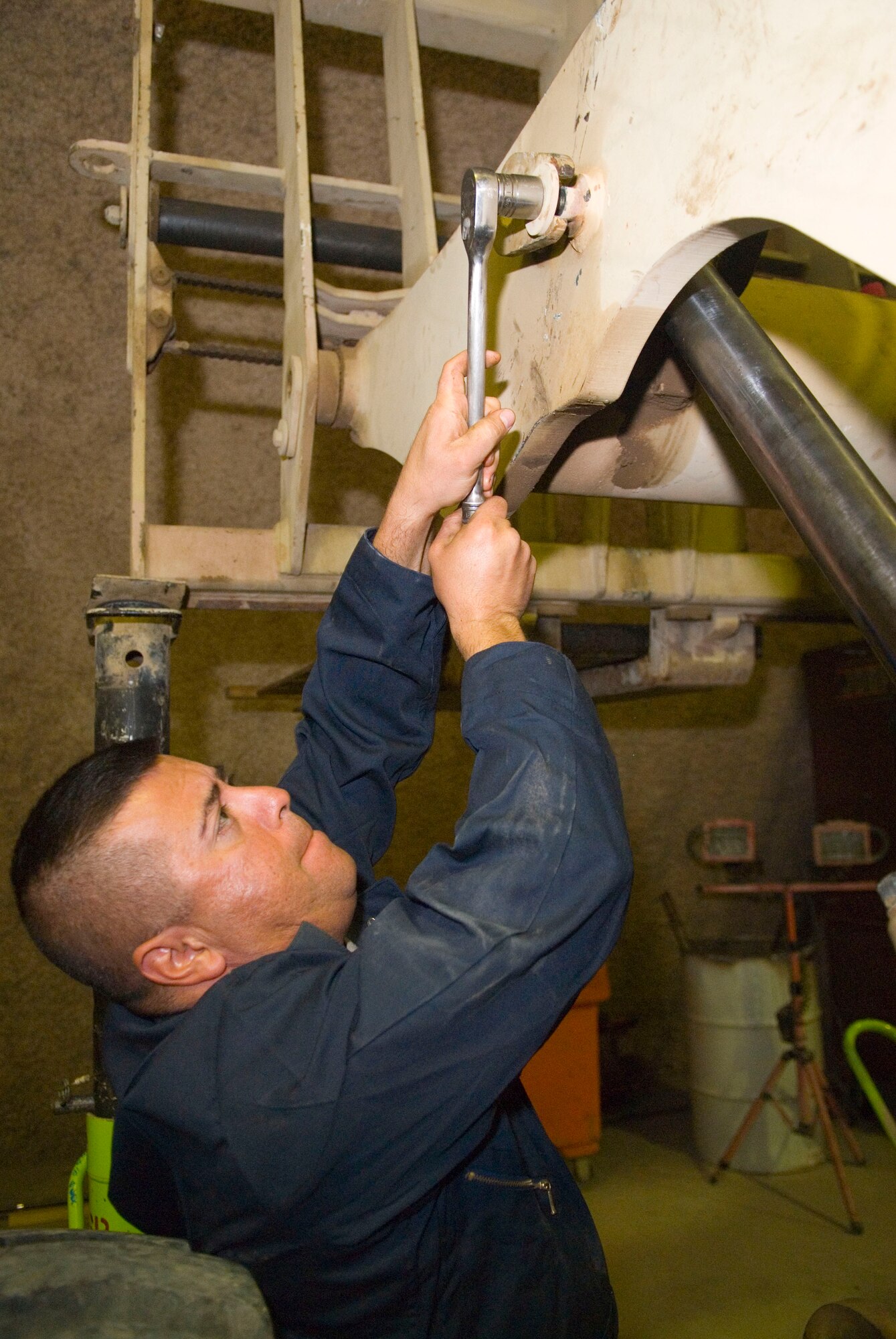BALAD AIR BASE, Iraq -- Tech. Sgt. Miguel Lopez, a 332nd Expeditionary Logistics Readiness Squadron vehicle maintainer, fastens a hydraulic cylinder hold down pin on a 10K all terrain forklift here, Dec. 21. The pin connects the hydraulic pump to the forks on the vehicle. Sergeant Lopez is deployed from Holloman Air Force Base, N.M. (U.S. Air Force photo/Staff Sgt. Joshua Garcia) 