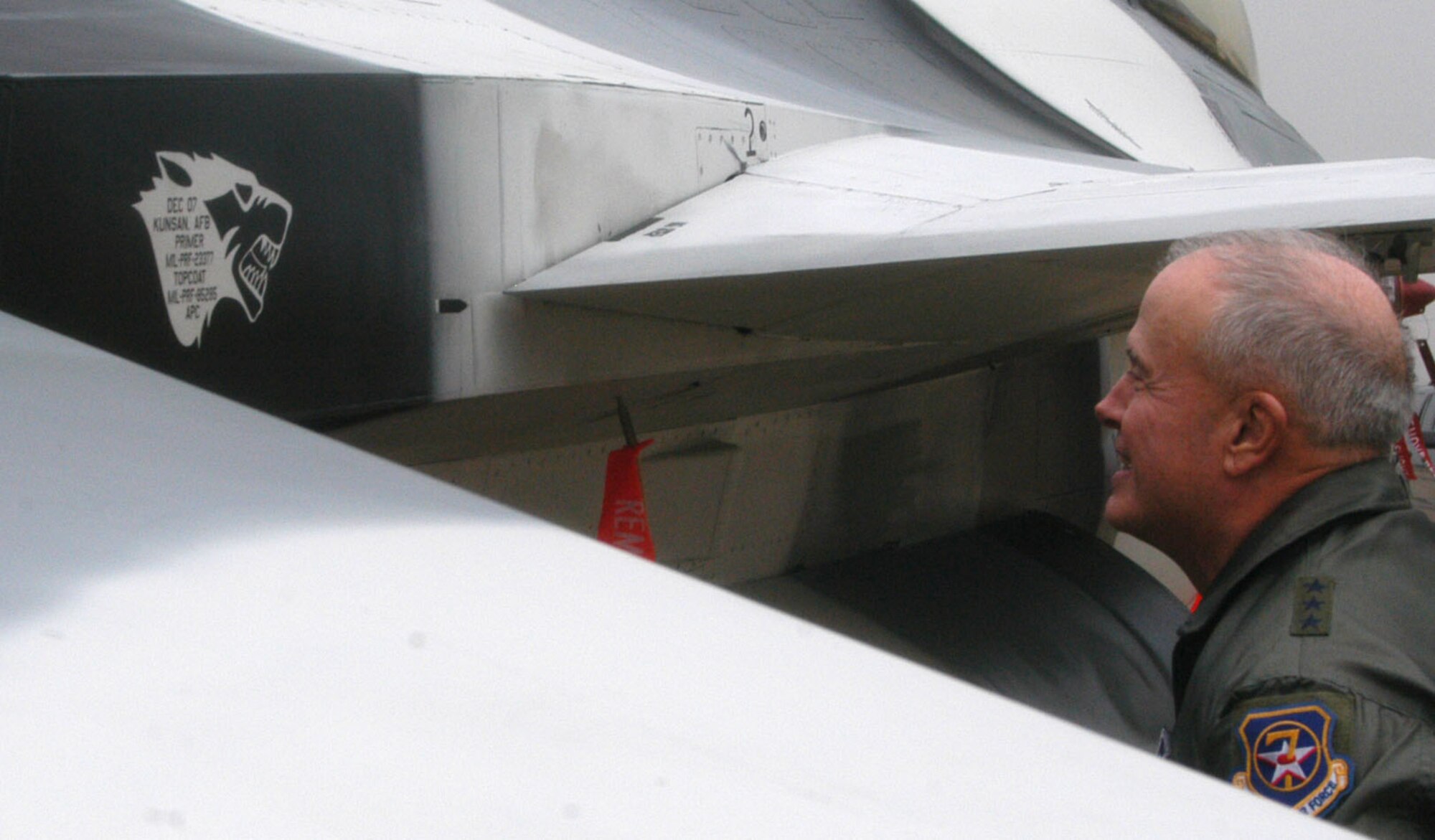KUNSAN AIR BASE, South Korea -- Lieutenant Gen. Stephen Wood, 7th Air Force commander admires the paint designation on an artic paint scheme F-16 during his visit to the base Dec. 21. Besides visiting Airmen on the flight line, the general is participating in the wing tree lighting ceremony and holiday party. (U.S. Air Force photo/Master Sgt. Sean P. Houlihan)