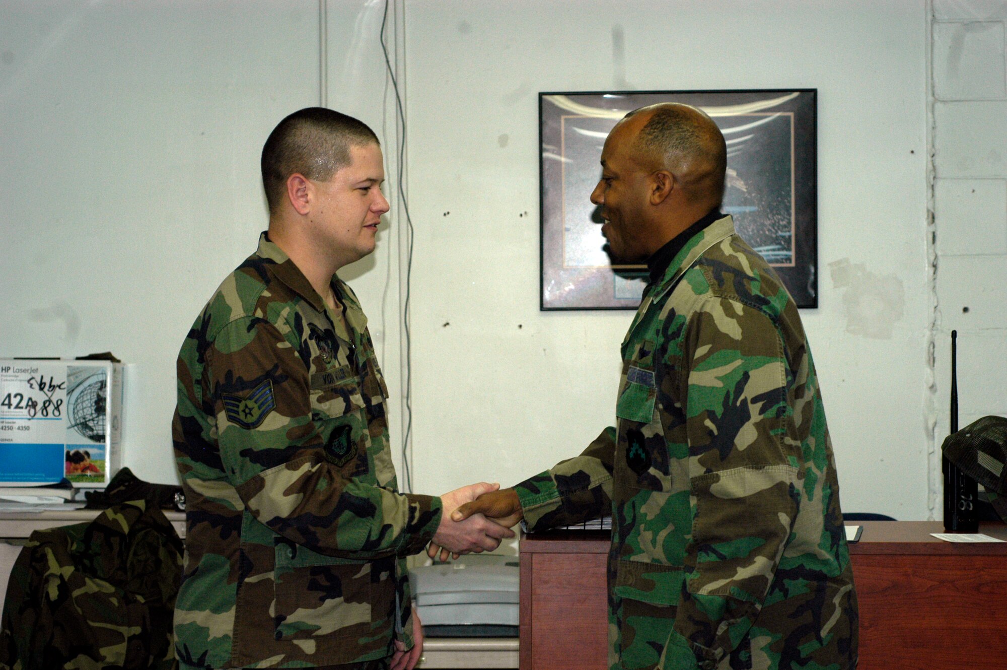 KUNSAN AIR BASE, South Korea --  Colonel CQ "Wolf" Brown, 8th Fighter Wing commander, congratulates Staff Sgt. Brandon Von Willer, 8th Logistics Readiness Squadron assistant NCO in charge of personal property, here Dec. 14. Sergeant Von Willer was recognized as the wing's Pride of the Pack for the week of Dec. 10. (U.S. Air Force photo/Staff Sgt. Alice Moore)
