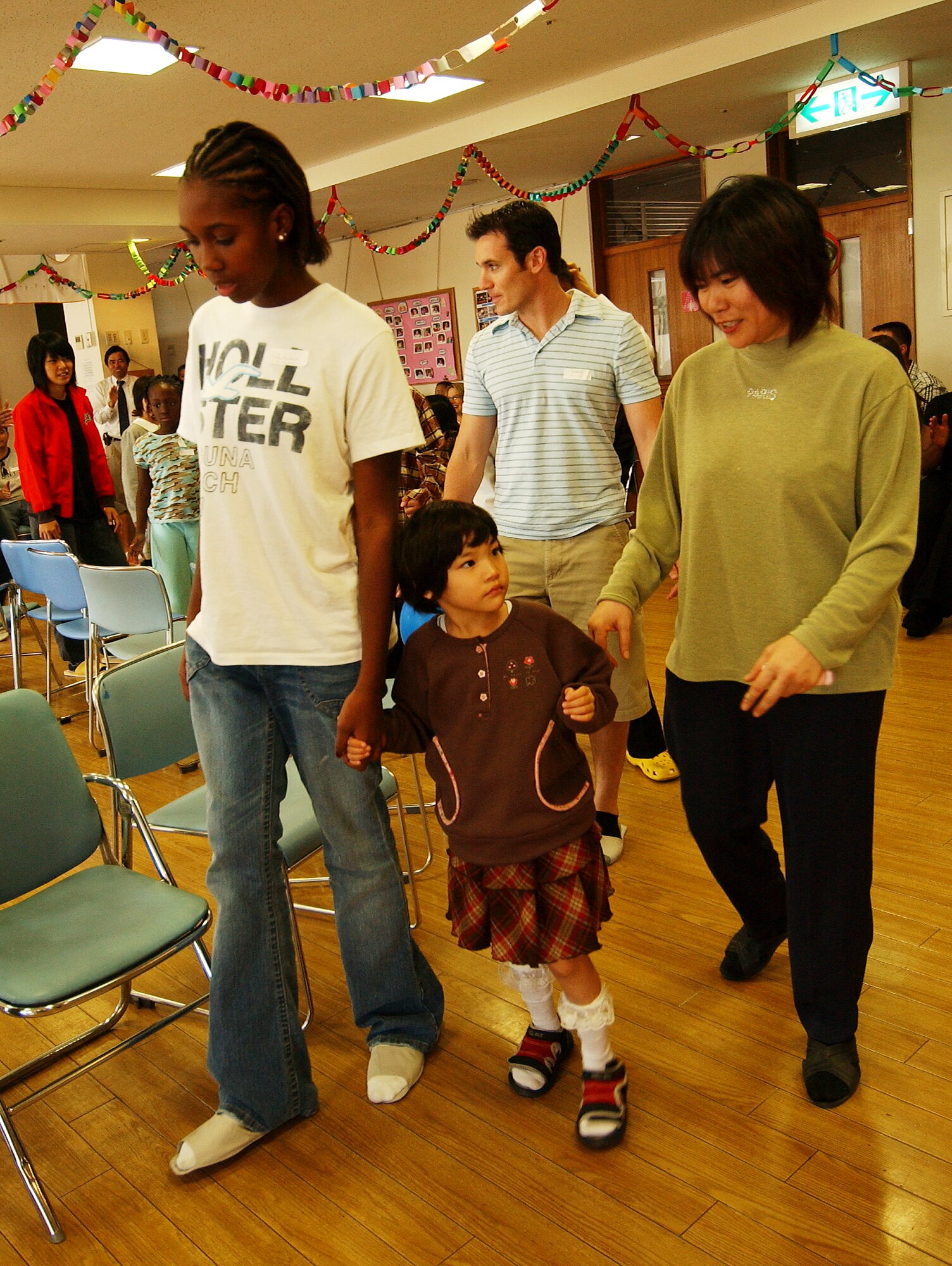 Autumn Brooks plays musical chairs with Yui Kakimuna, while her mother is by her side, during a visit to a special needs home for the mentally challenged located in Haebaru town Dec. 16, Okinawa, Japan. The volunteers participated in games with the children and provided desserts along with presenting Christmas gifts. 
(U.S. Air Force photo/Tech. Sgt. Rey Ramon)

