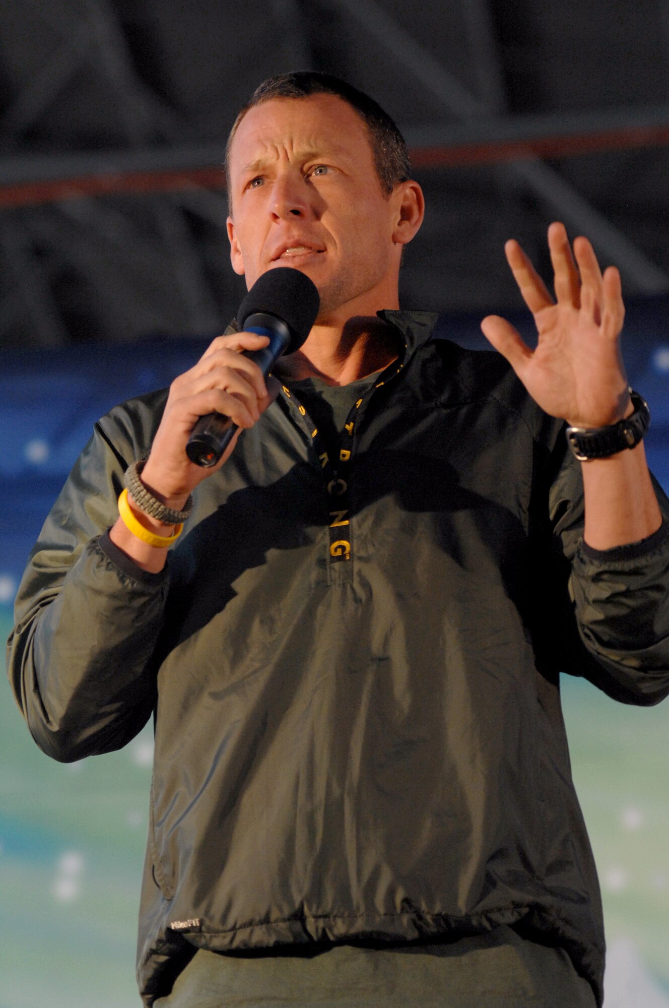 AVIANO AIR BASE, Italy-- Lance Armstrong speaks to the Aviano community duing the USO Tour 2007, on Dec. 22, 2007.   Navy Adm. Michael G. Mullen, chairman of the Joint Chiefs of Staff, arrived in Aviano early Saturday afternoon from down range, bringing entertainers and celebrities Robin Williams, Lewis Black, Kid Rock, Lance Armstrong, Rachel Smith, the reigning Miss USA, and Ronan Tynan an Irish Tennor on the Chairman's United Service Organizations Holiday tour. (U.S. Air Force photo/Airman 1st Class Tabitha M. Mans) 