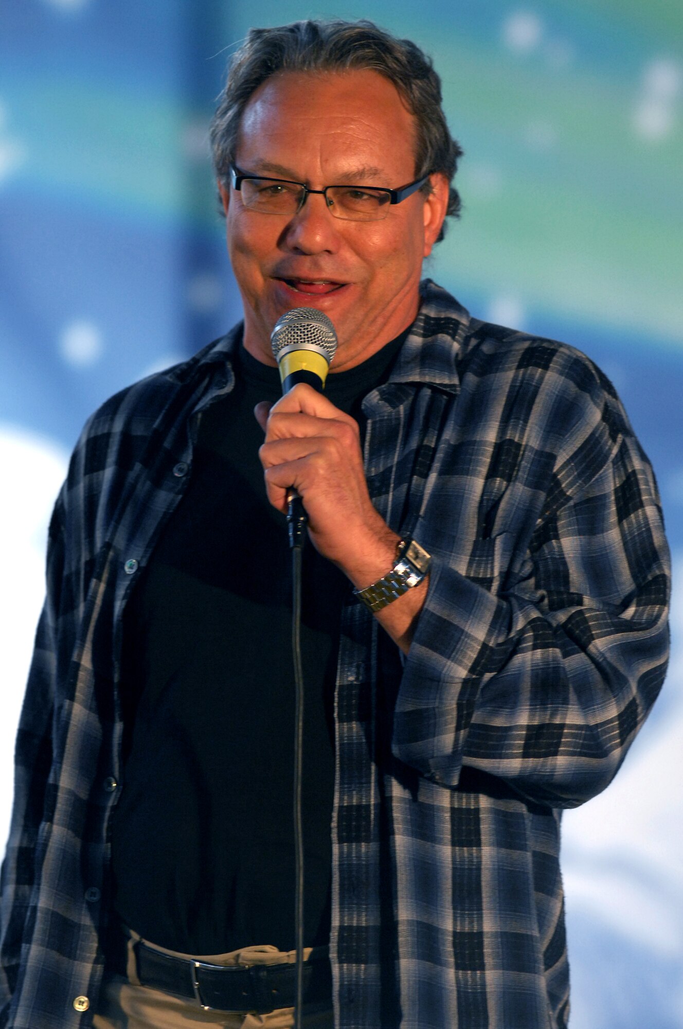 AVIANO AIR BASE, Italy-- Comedian Lewis Black performs as part of a USO holiday show held for the Aviano community, Dec. 22, 2007.   Navy Adm. Michael G. Mullen, chairman of the Joint Chiefs of Staff, arrived in Aviano early Saturday afternoon from down range, bringing entertainers and celebrities Robin Williams, Lewis Black, Kid Rock, Lance Armstrong, Rachel Smith, the reigning Miss USA, and Ronan Tynan an Irish Tennor on the Chairman's United Service Organizations Holiday tour.  (U.S. Air Force photo/Staff Sgt. Michael R. Holzworth) 