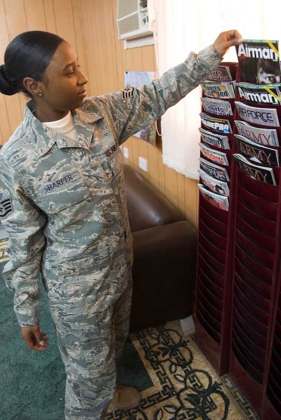 BALAD AIR BASE, Iraq -- Staff Sgt. Nate Harper, 332nd Expeditionary Services Squadron head librarian, straightens up the magazine rack in the library here as part of her daily routine. Sergeant Harper is deployed from Langley Air Force Base, Va. (U.S. Air Force photo/Staff Sgt. Travis Edwards)