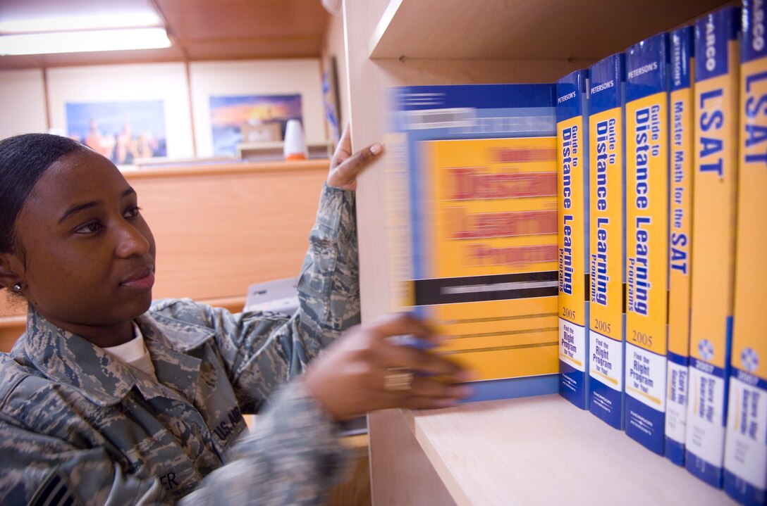 BALAD AIR BASE, Iraq -- Staff Sgt. Nate Harper, 332nd Expeditionary Services Squadron head librarian, places back a guide that informs readers about choices in distance learning, on a bookshelf here. The library also has College Level Examination Program and Defense Activity for Non-Traditional Education Support study guides to check out 24 hours-a-day. Sergeant Harper is deployed from Langley Air Force Base, Va. (U.S. Air Force photo/Staff Sgt. Travis Edwards)
