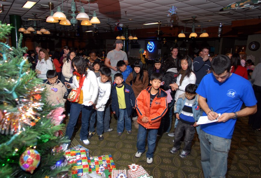 KUNSAN AIR BASE -- Children from the AeYuke orphanage wait to receive Christmas gifts during a visit here Dec. 22.  Airmen from the 35th Fighter Squadron spent the afternoon with more than 65 children from a local orphanage touring an F-16 Fighting Falcon and flight simulator, handing out gifts, and playing.  The visit is part of the Good Neighbor Program which helps strengthen relations between Kunsan and the Korean community.  (U.S. Air Force photo/Senior Airman Steven R. Doty)