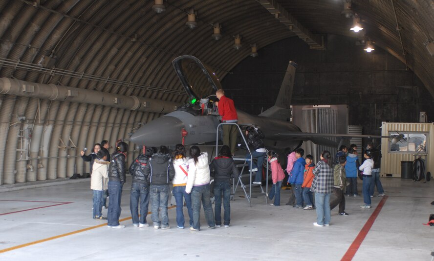KUNSAN AIR BASE -- Children from the AeYuke orphanage get a first hand look at an F-16 Fighting Falcon for the first time here Dec. 22.  Airmen from the 35th Fighter Squadron spent the afternoon with more than 65 children from a local orphanage touring an F-16 Fighting Falcon and flight simulator, handing out gifts, and playing.  The visit is part of the Good Neighbor Program which helps strengthen relations between Kunsan and the Korean community.  (U.S. Air Force photo/Senior Airman Steven R. Doty)