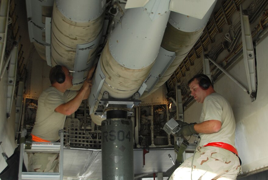 SOUTHWEST ASIA - Staff Sgt. Brandon Neitz (left) and Tech. Sgt. James Sheldon, 379th Expeditionary Maintenance Squadron, load 2,000 pound bombs on a B-1B Lancer Dec. 21 to prepare it for a mission at a Southwest Asia air base. Both sergeants are deployed from Dyess Air Force Base, Texas. (U.S. Air Force photo/Staff Sgt. Douglas Olsen)