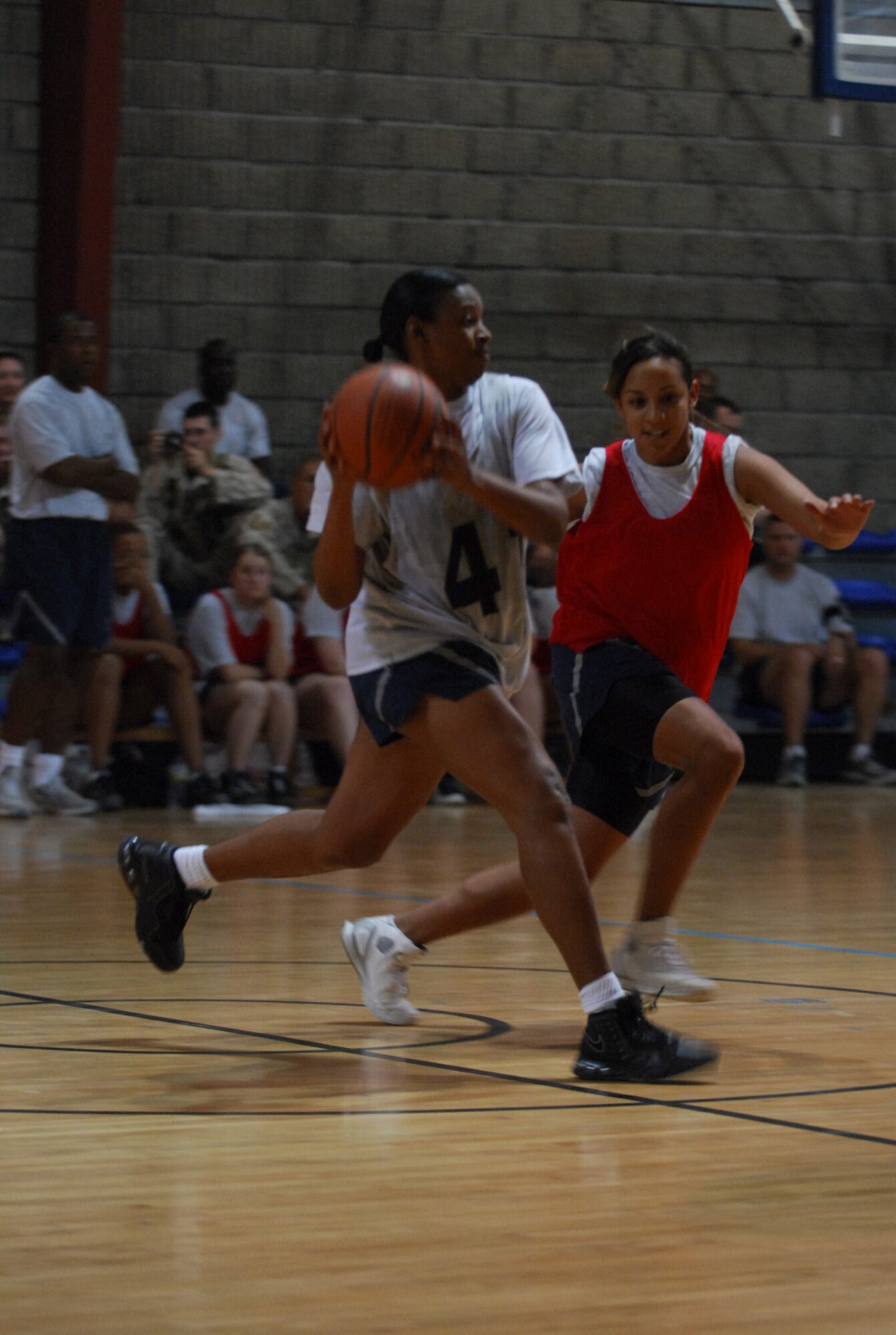 SOUTHWEST ASIA - Tech. Sgt. Sabrina Foster attempts to make a pass as Senior Airman Liza Escalante defends during a women's basketball game Dec. 17 at a Southwest Asia air base.  Sergeant Foster is deployed from Scott Air Force Base, Ill. and Airman Escalante is deployed from Kirtland AFB, N.M. (U. S. Air Force photo/ Staff Sgt. Douglas Olsen)