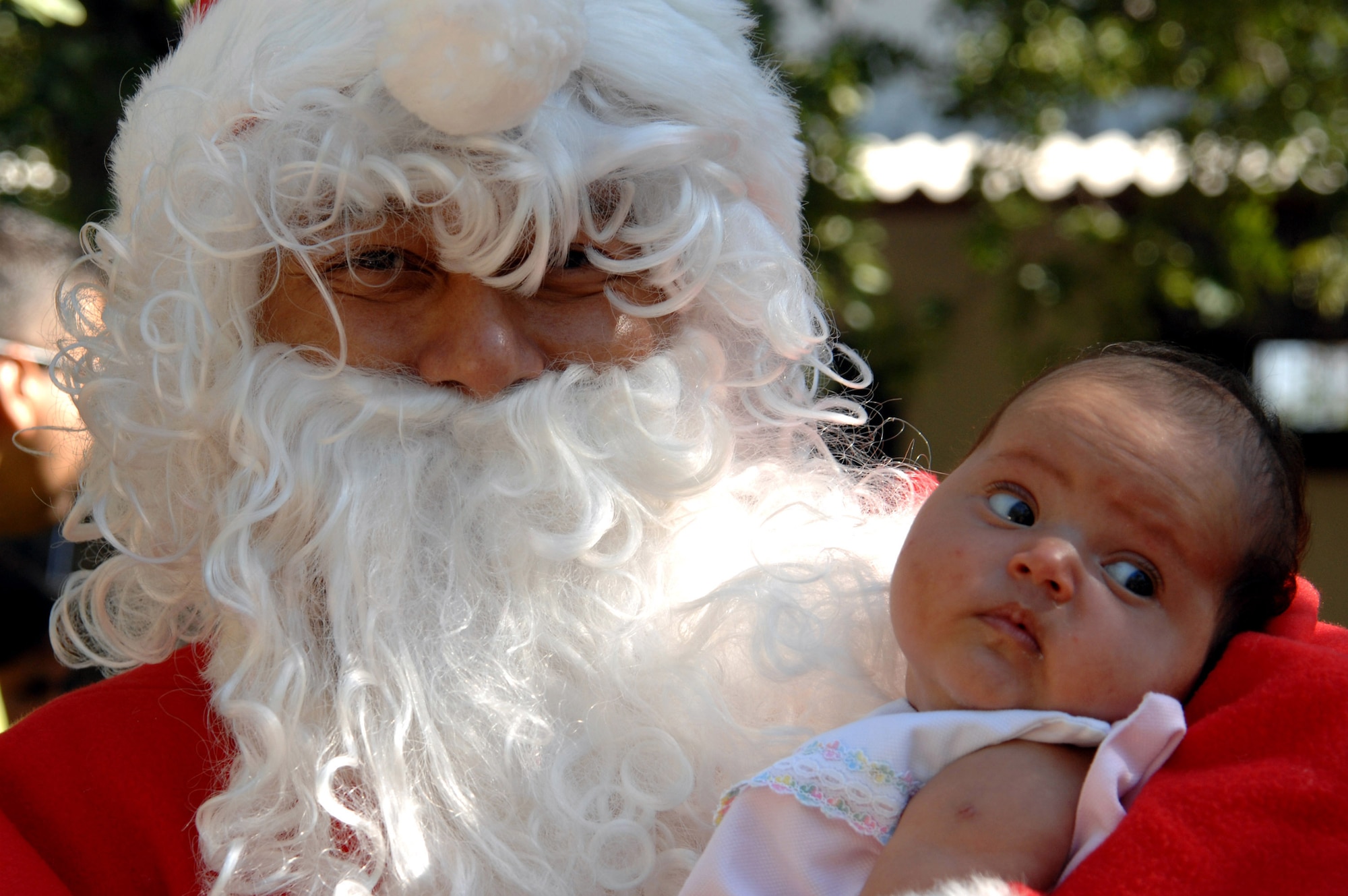 Santa Claus gets his picture taken with an orphan girl from Hogar San Antonio de Padua Orphanage in Comayagua, Honduras.  Operation Christmas Wish is an annual trip made by Airmen from the 1st Special Operations Wing who deliver more than 9,000 lbs of Christmas packages to hundreds of Honduran orphans.  Santa is Tech. Sgt. Norman Padilla Cruz from the 1st Special Operations Aeromedical Squadron.  U.S. Air Force photo/Senior Airman Stephanie Jacobs)