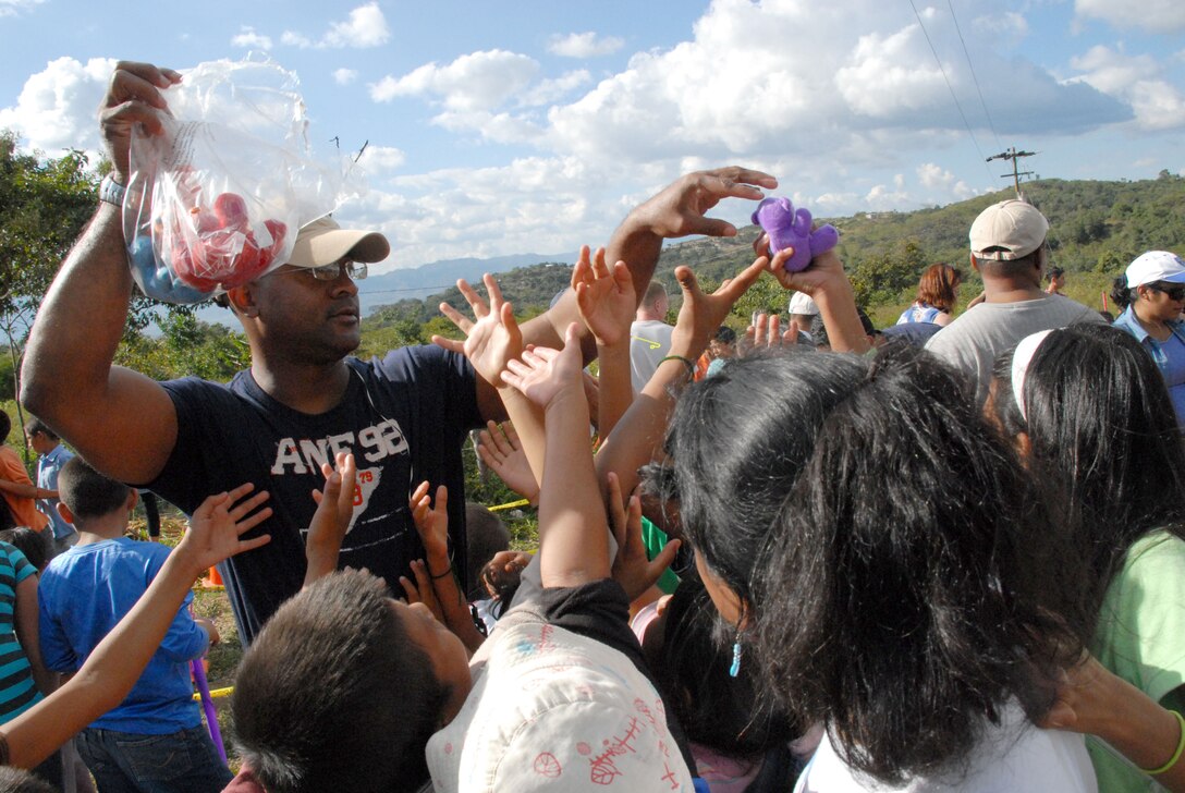 COMAYAGUA, Honduras -- Air Force Maj. Anthony Jacobs, the personnel director for Joint Task Force-Bravo, hands out stuffed animals to Honduran children here Dec. 23 during a toy giveaway. The toy drive was organized by the Joint Task Force-Bravo Chapel and the gifts were donated by the families of servicemembers stationed at Soto Cano Air Base, Honduras.  (U.S. Air Force photo by Tech. Sgt. Sonny Cohrs) 