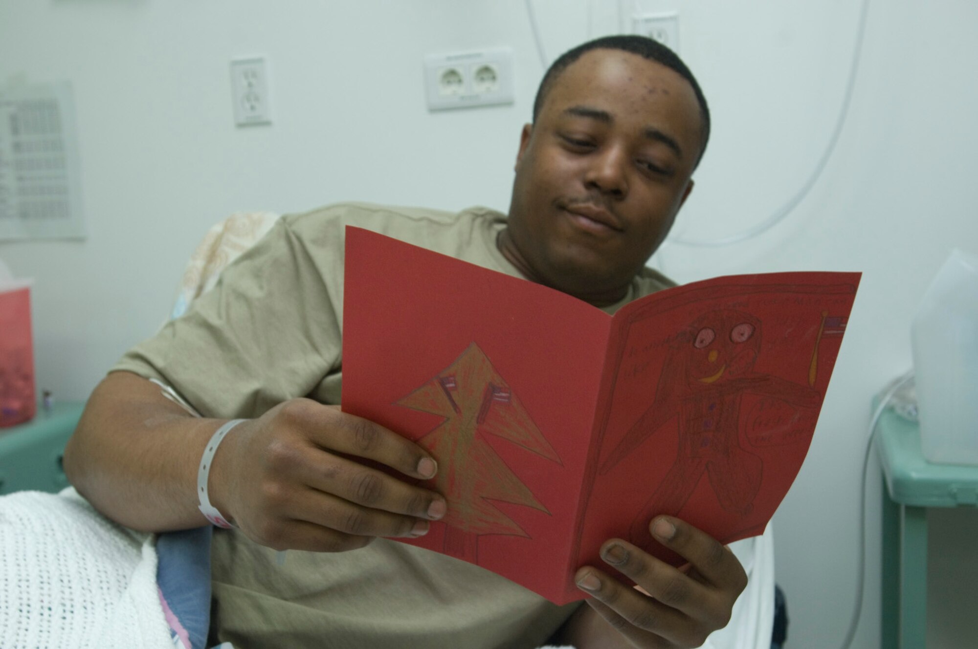 BALAD AIR BASE, Iraq -- Army Pfc. Bryant Cedrick, deployed to Camp Taji, reads a holiday card from R.C. Hinsdale Elementary School in Edgewood, Ky. on Dec. 24. Private Cedrick, a native of Warner Robins, Ga., is recovering from an illness at the Air Force Theater Hospital here. The hospital is the most comprehensive medical facility in Iraq. Private Cedrick is deployed from Fort Carson, Colo. (U.S. Air Force photo/Tech. Sgt. D. Clare)