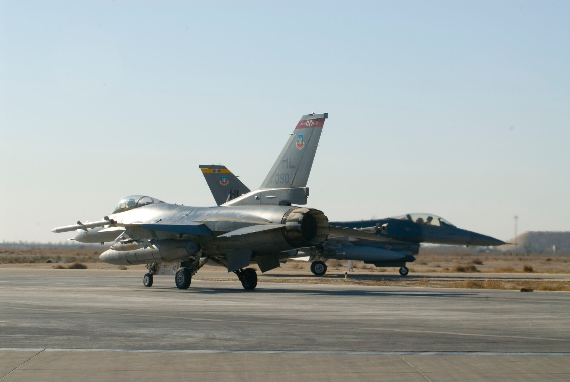BALAD AIR BASE, Iraq -- Two F-16 Fighting Falcon aircraft taxi to the runway after being armed for a mission, here, Dec. 24. The aircraft are assigned to the 4th Expeditionary Fighter Squadron which executes combat missions daily providing overwatch to troops on the ground in Iraq. (U.S. Air Force photo/Staff Sgt. Joshua Garcia) 