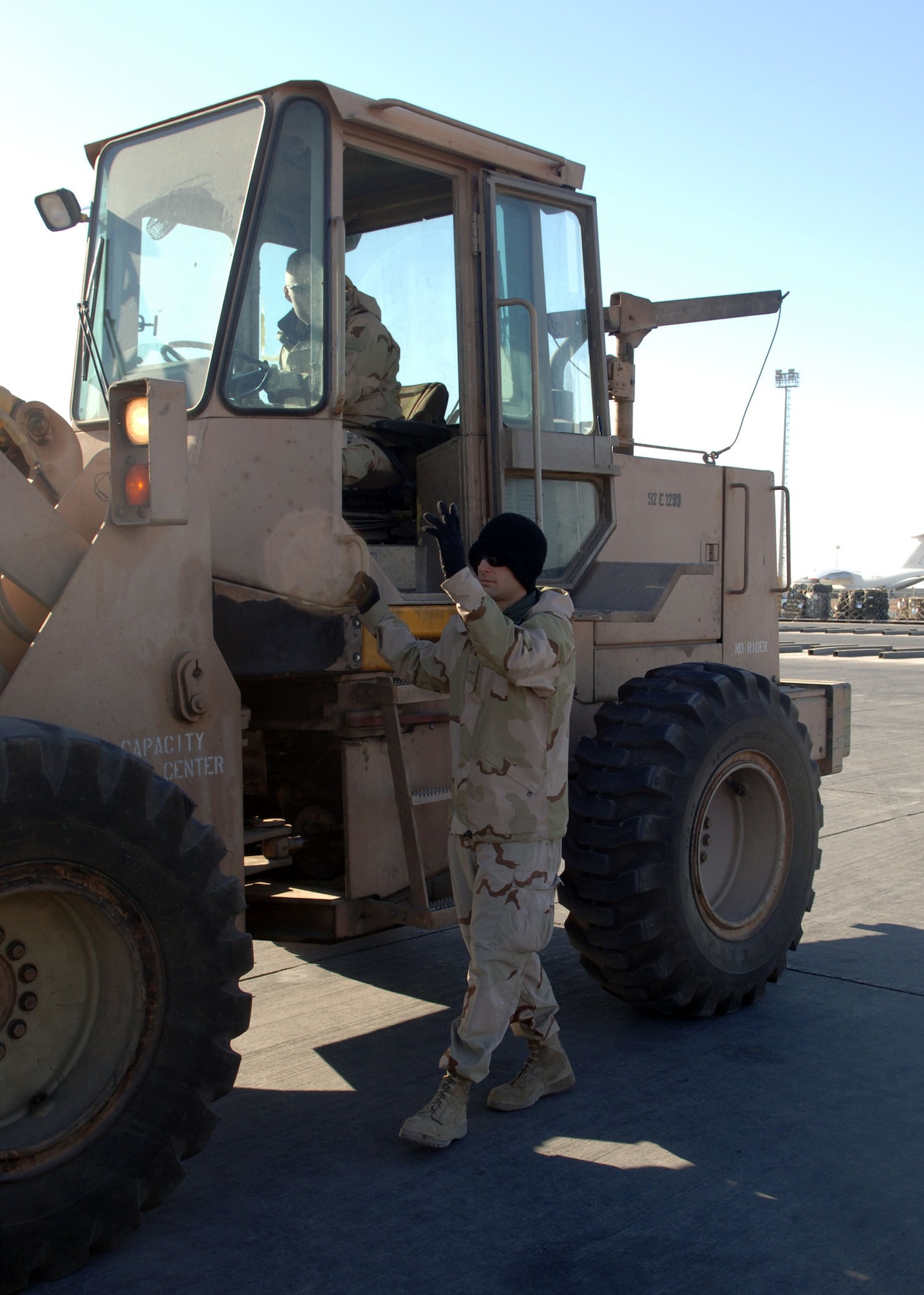 BALAD AIR BASE, Iraq – Airman 1st Class John Rooker, a 332nd Expeditionary Logistics Readiness Squadron Aerial Port Flight transportation specialist, spots a forklift for Airman 1st Class John Lindner, a fellow transportation specialist. Both Airmen are deployed from Pope Air Force Base, N.C. (U.S. Air Force photo/Senior Airman Terri Barriere)