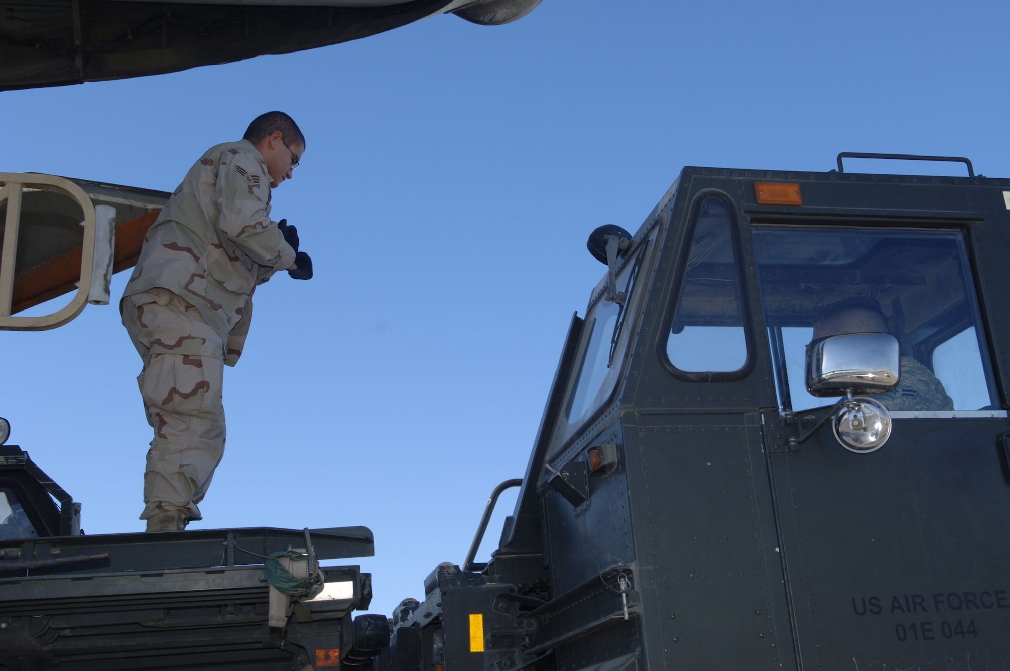 BALAD AIR BASE, Iraq – Senior Airman Andres Silvera, a 332nd Expeditionary Logistics Readiness Squadron Aerial Port Flight transportation specialist, guides a k-loader into place to offload cargo. Airman Silvera is deployed from Pope Air Force Base, N.C. (U.S. Air Force photo/Senior Airman Terri Barriere)